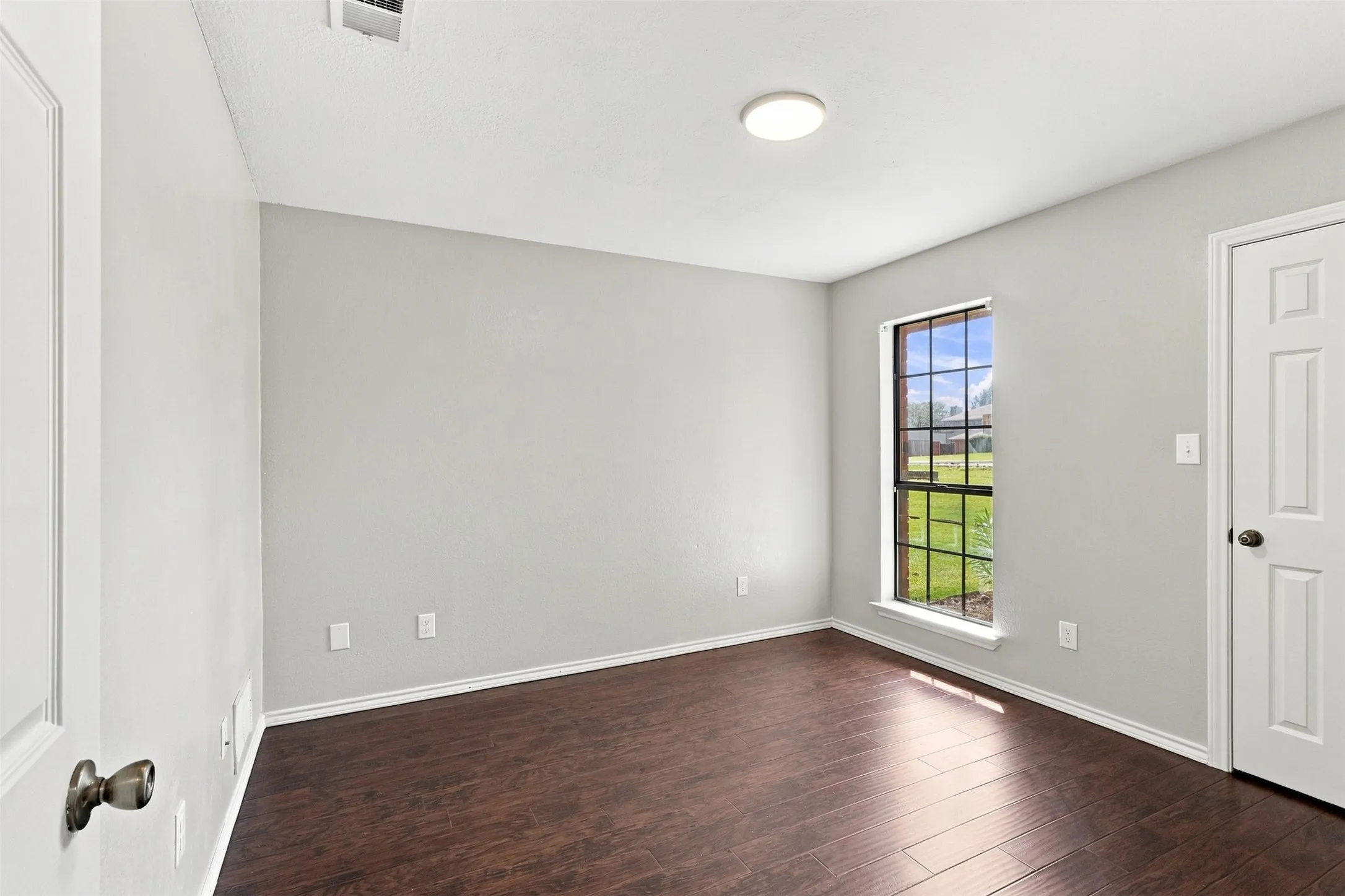 Vaulted ceiling with an arched decorative window, dual vanity with white cabinetry, walk-in shower with clear glass enclosure, built-in bathtub with tiled surround, and tiled flooring