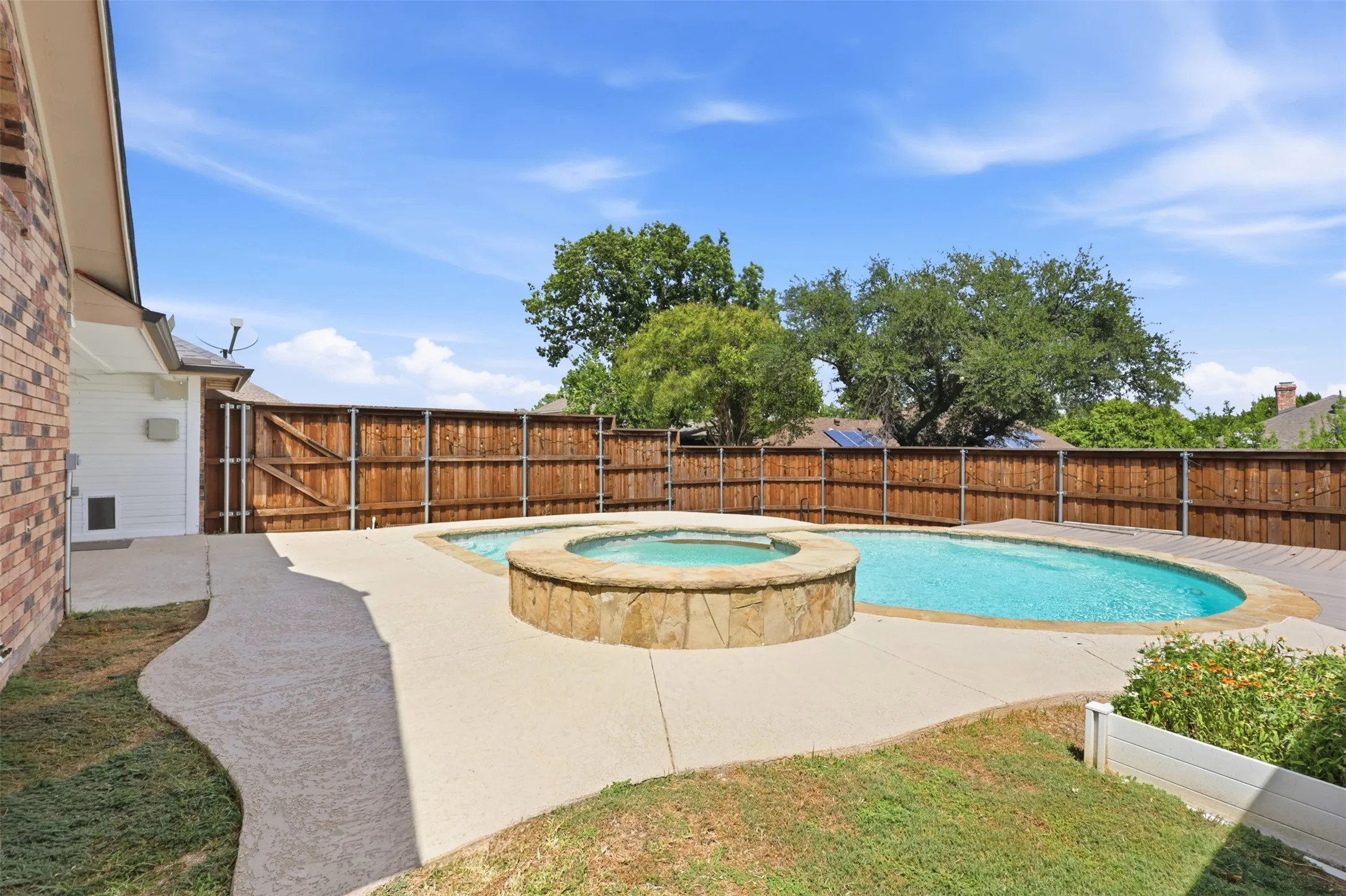 Private backyard with a swimming pool and built-in stone hot tub