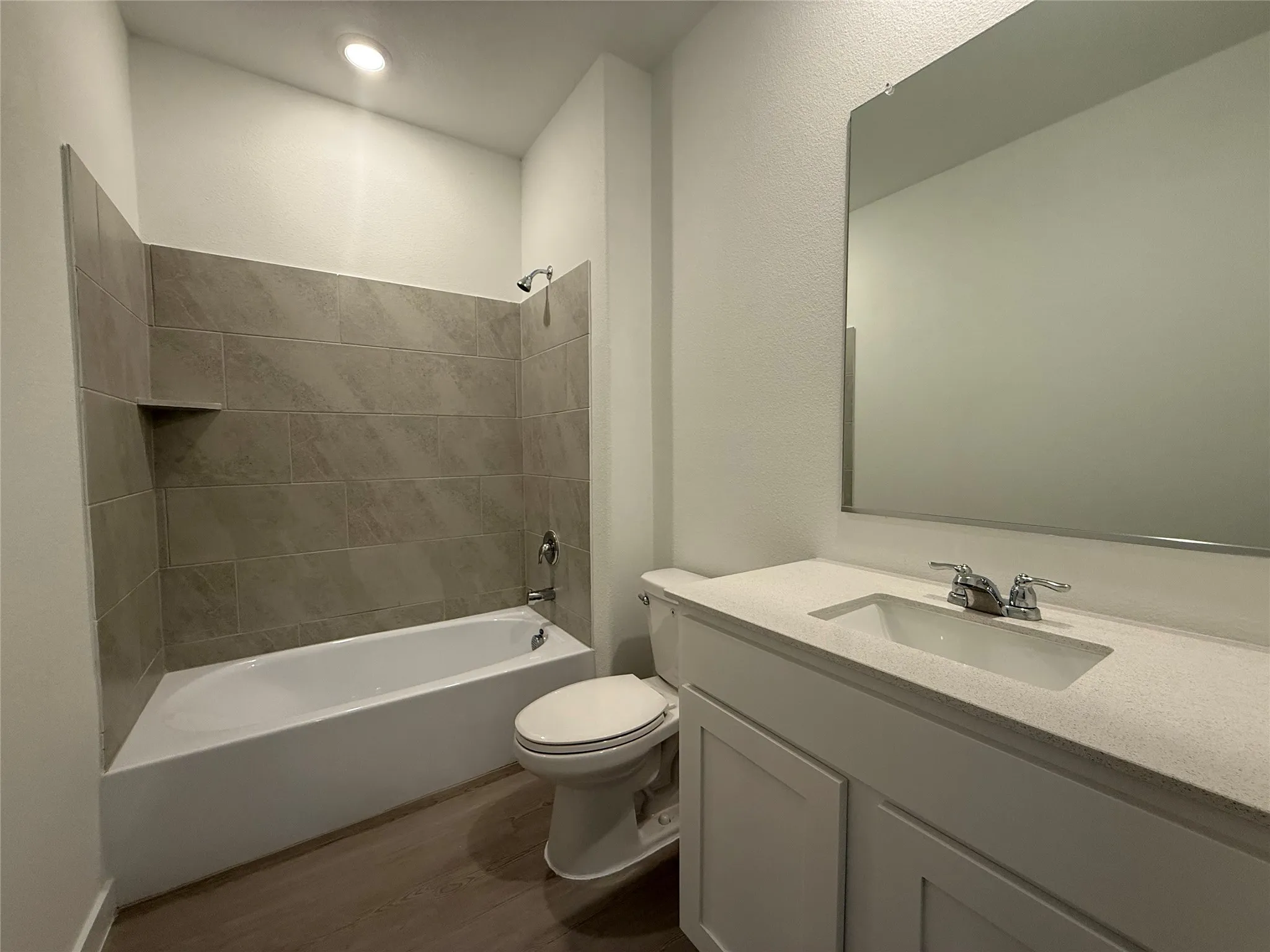Bathroom featuring a white vanity with an integrated sink, polished chrome faucet, and a large wall-mounted mirror