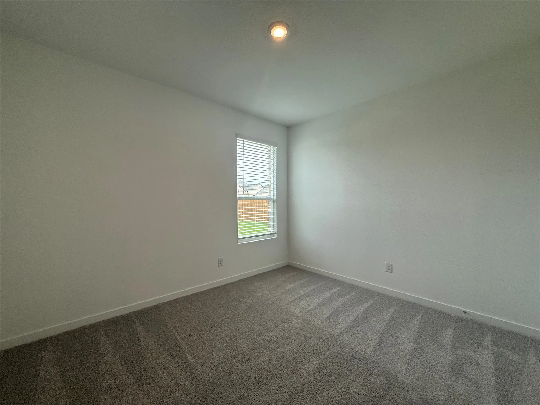 Recessed ceiling light, neutral wall paint, window with blinds, and carpeted flooring