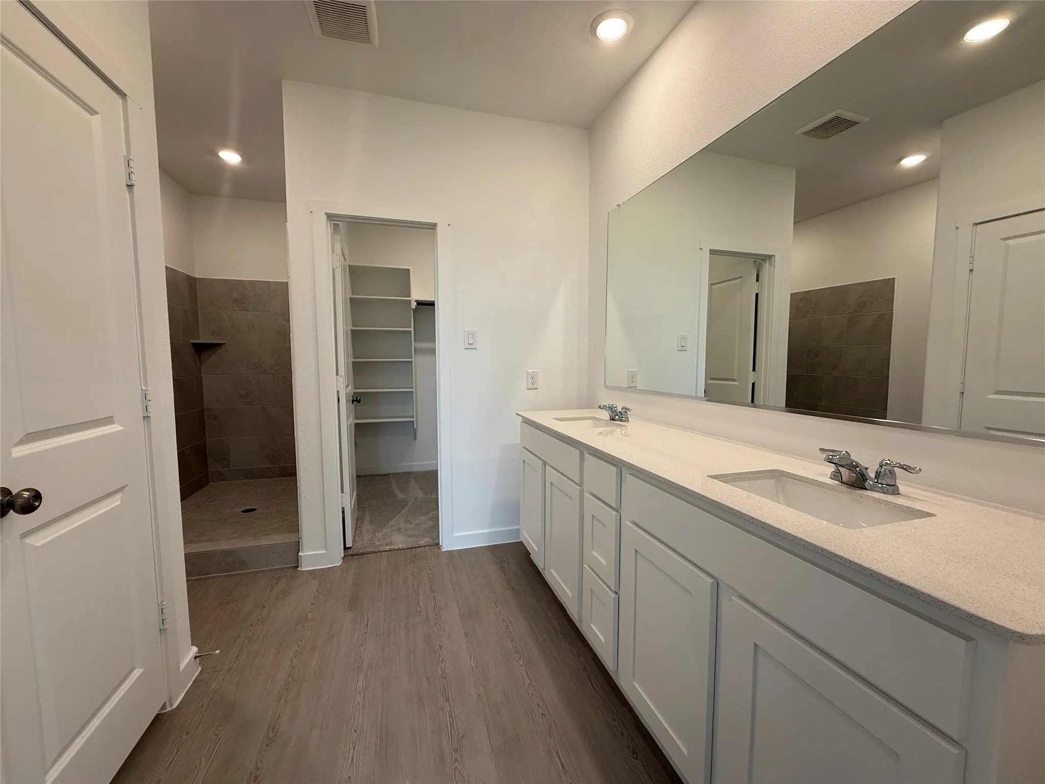 Dual vanity with white cabinetry, light-colored countertops, and chrome fixtures