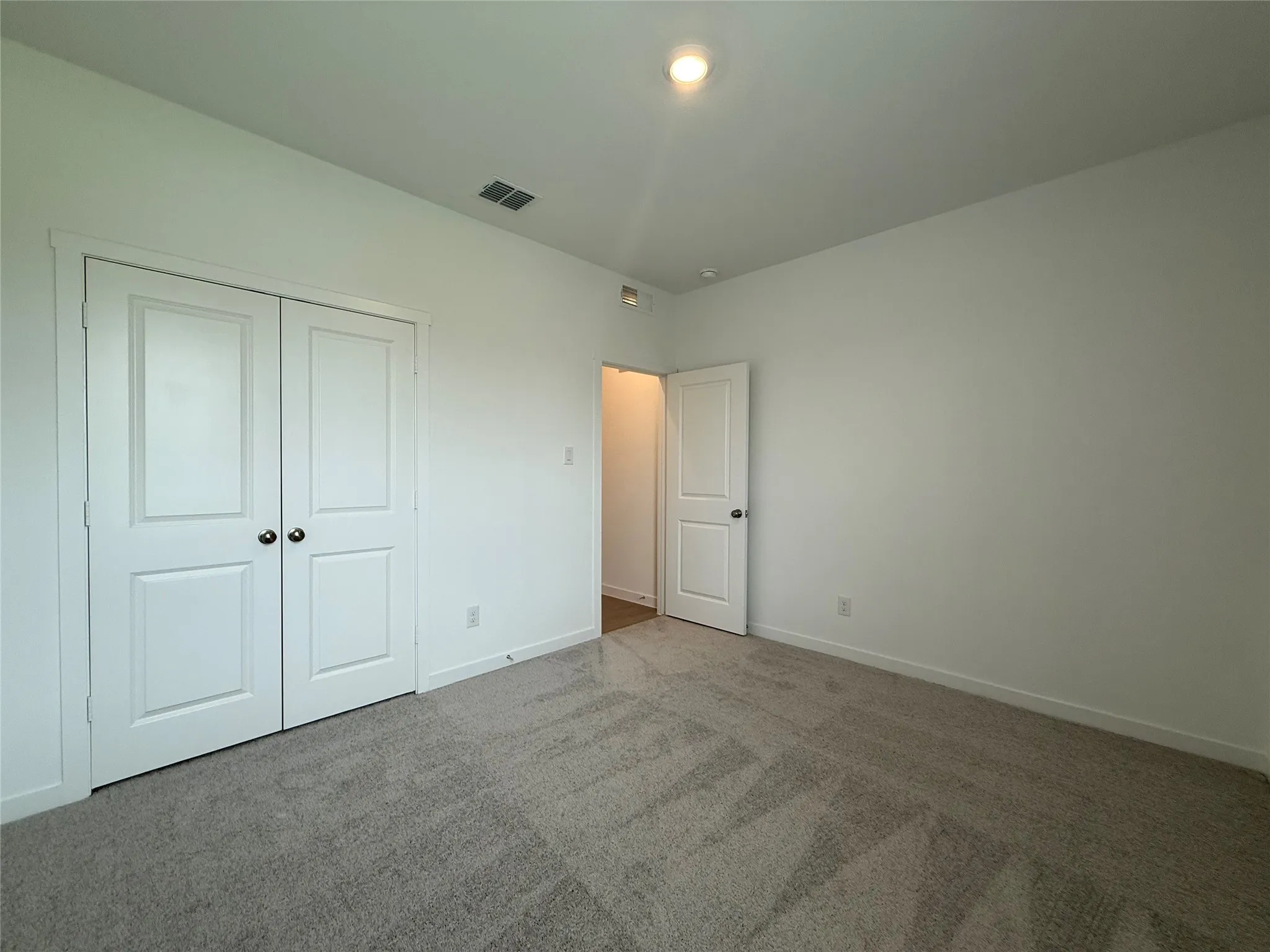 Neutral wall paint, recessed lighting, and carpet flooring