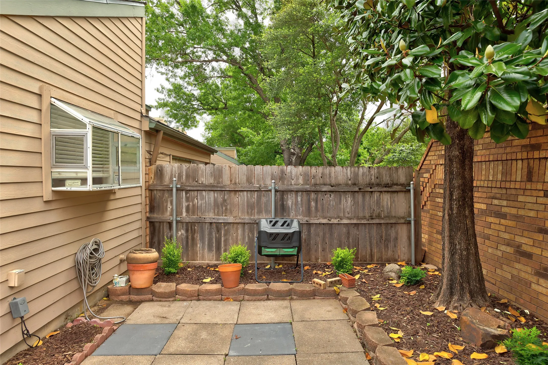 Patio area featuring square pavers and a surrounding wood fence
