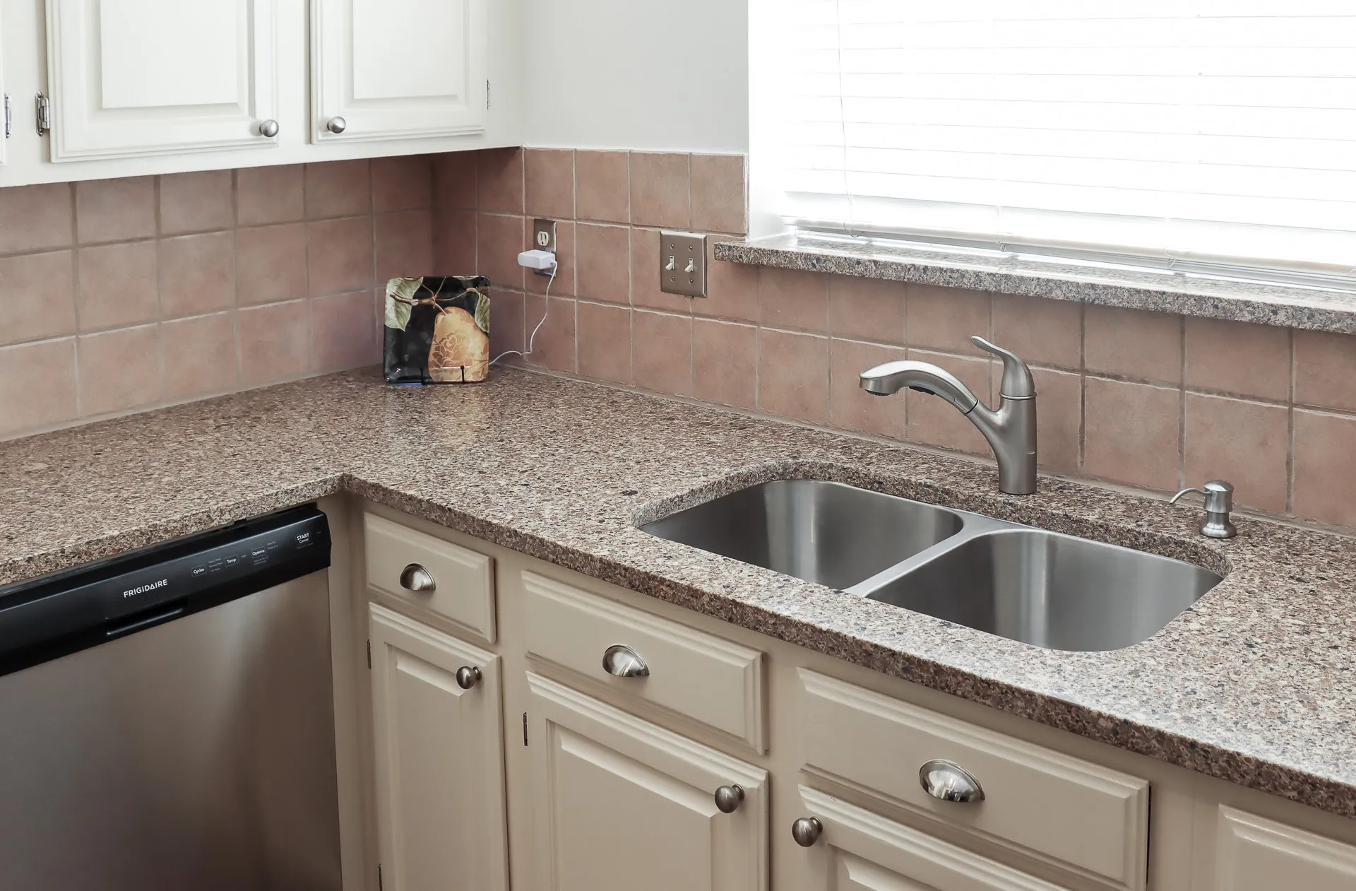 Kitchen with stainless steel double-basin sink and a coordinating tile backsplash