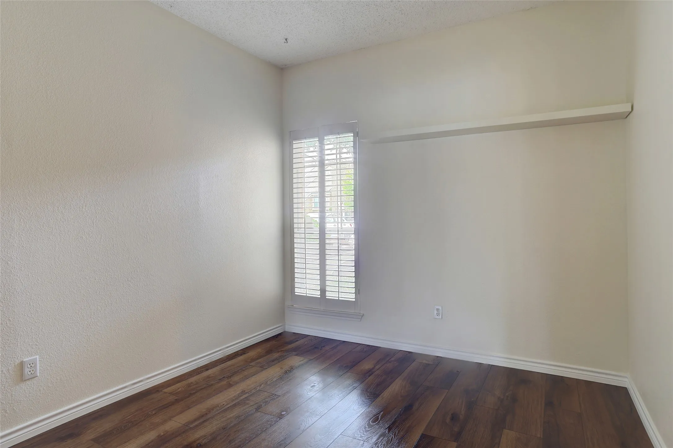 Next to the Primary Bedroom. Bright, featuring warm wood-finish flooring, plantation shutters, and a spacious closet with sliding door hardware. Optional play room, nursery or home office.