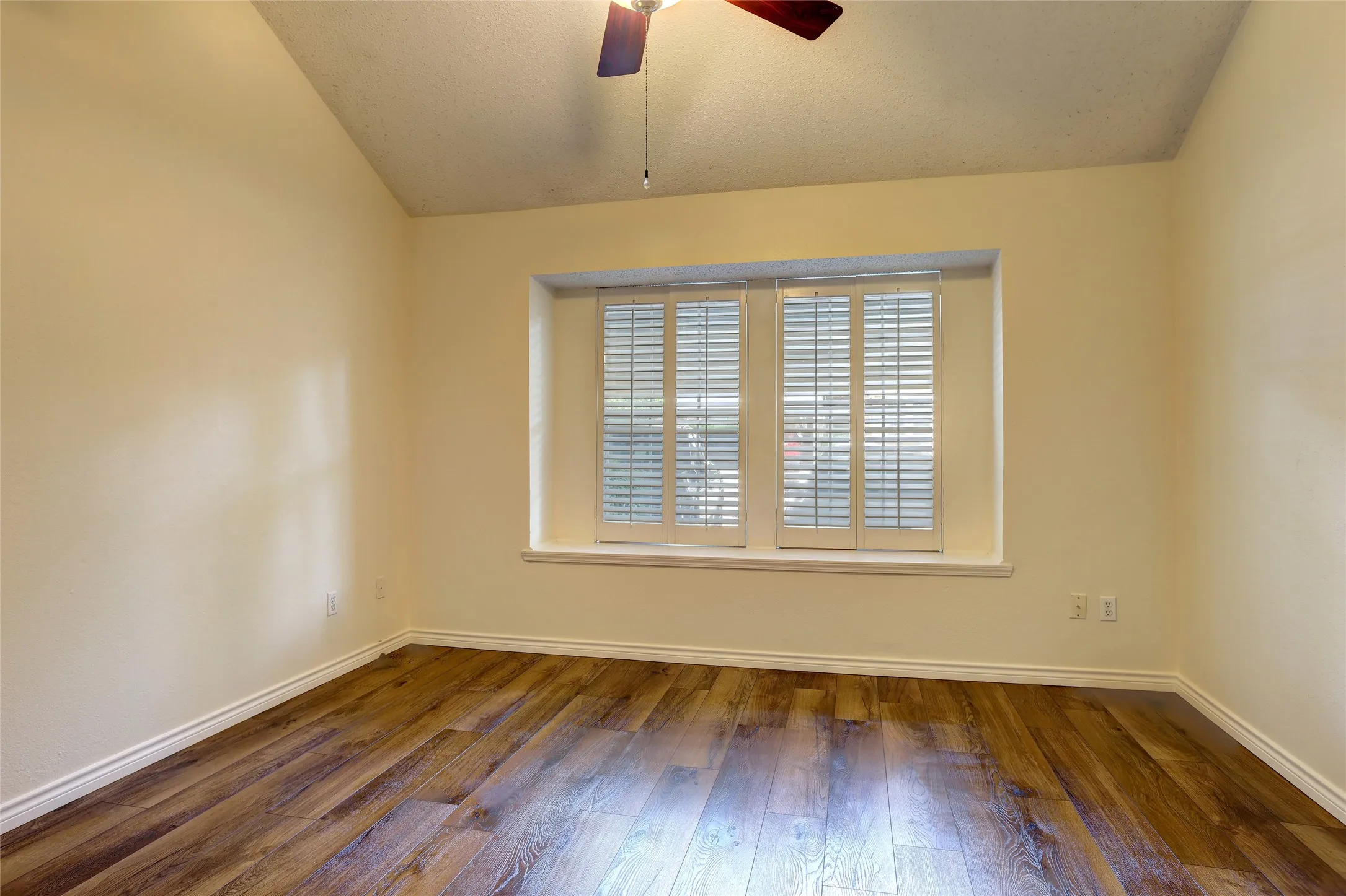 Very spacious with wood-finish flooring, plantation shutters, and a ceiling fan with integrated lighting