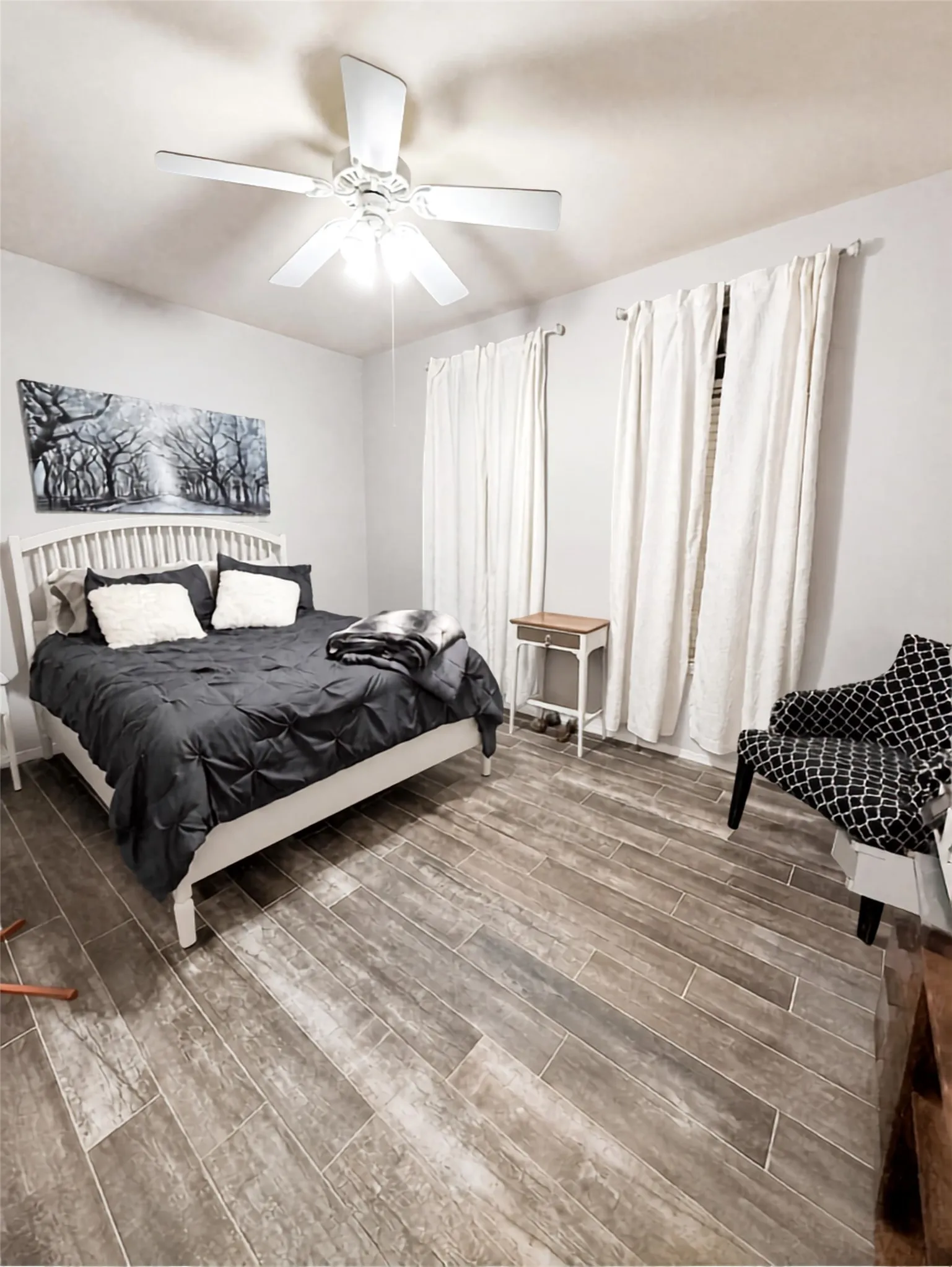 Wood-look plank flooring throughout, complemented by a ceiling fan with integrated lighting