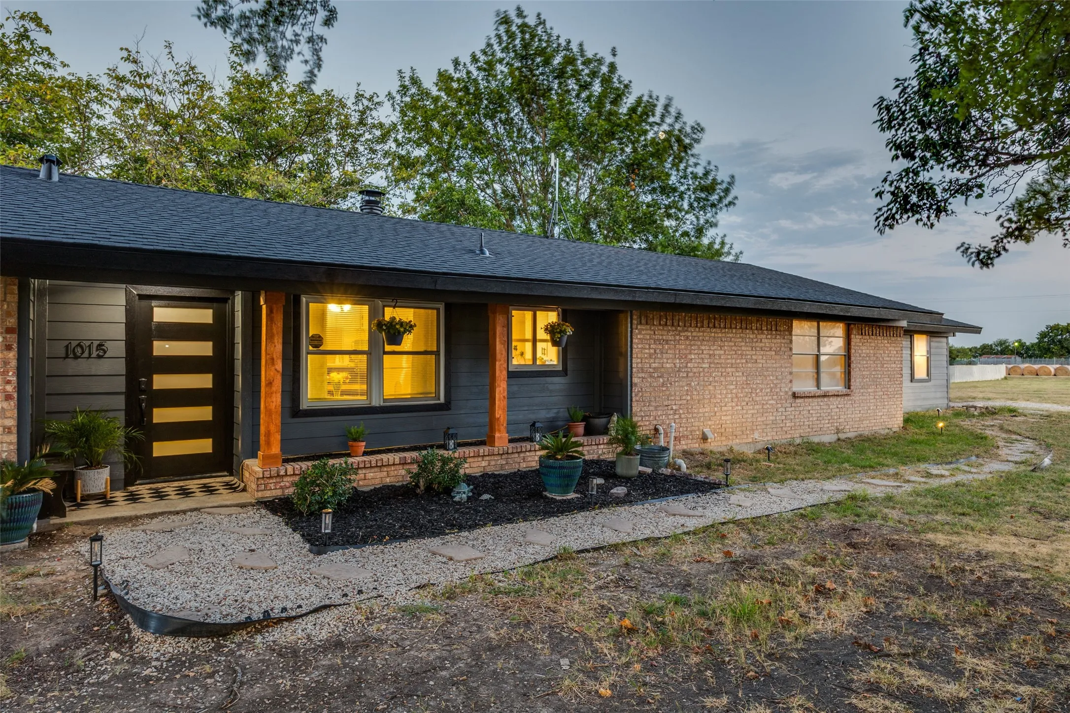 Contemporary exterior with a dark shingle roof, brick and horizontal siding, and a modern front door