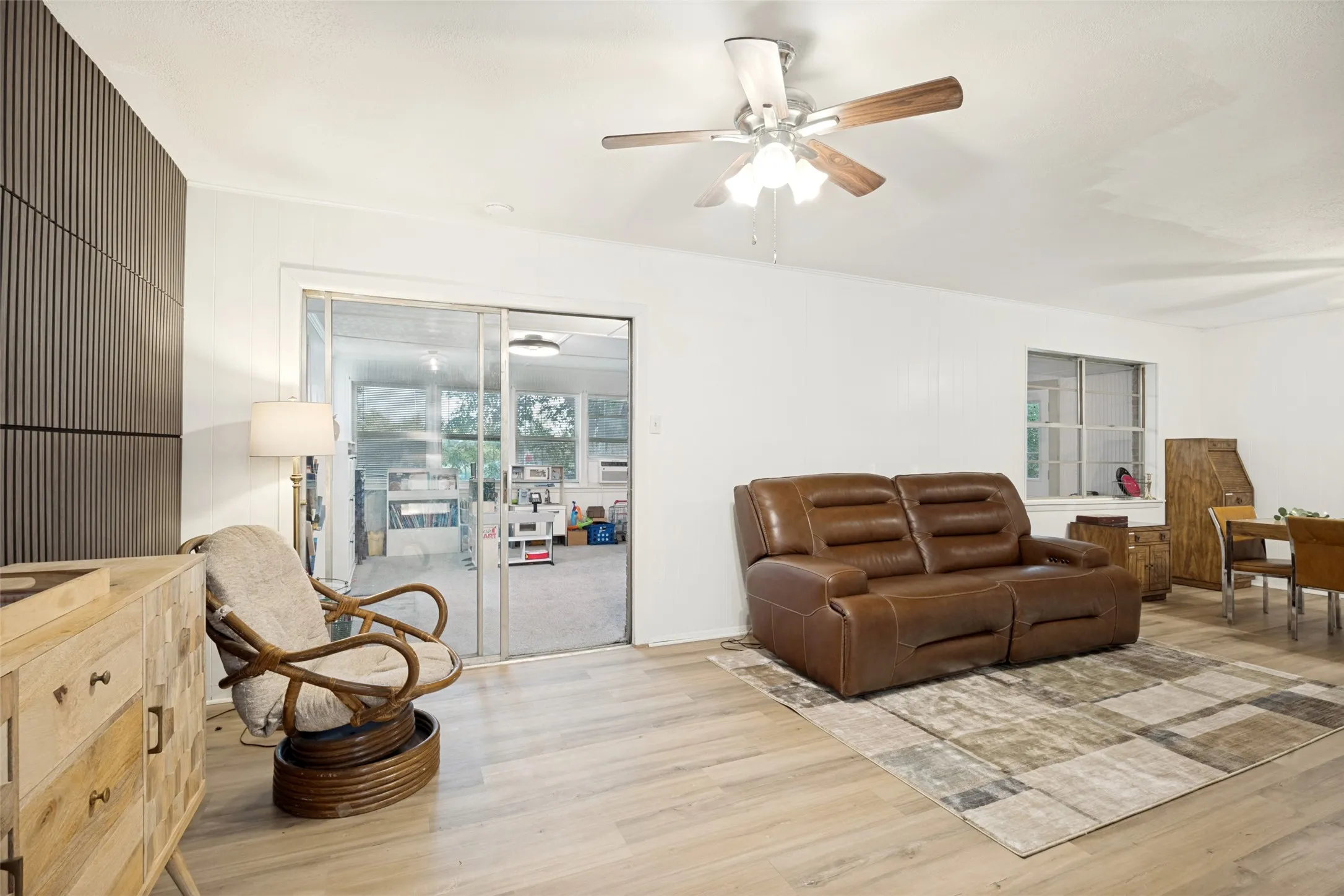 Wood-finish flooring, white walls, and a ceiling fan with wood-finish blades