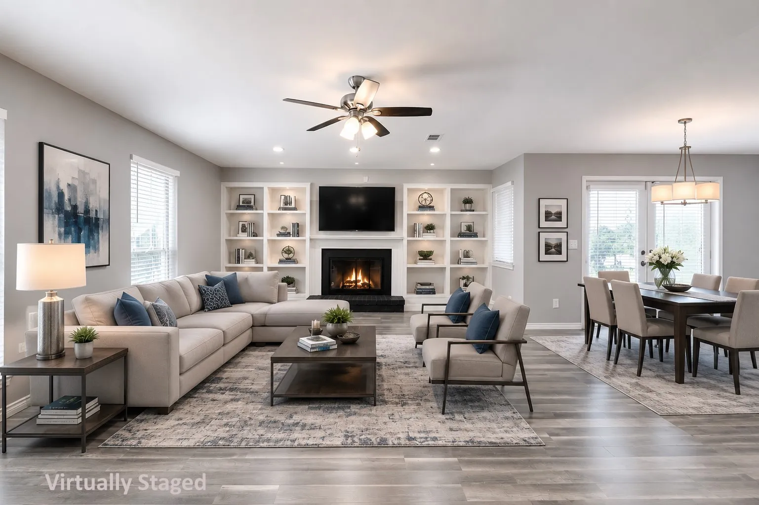 Open-concept living area with wood-finish flooring, a built-in fireplace with a mantel, integrated shelving, and recessed lighting