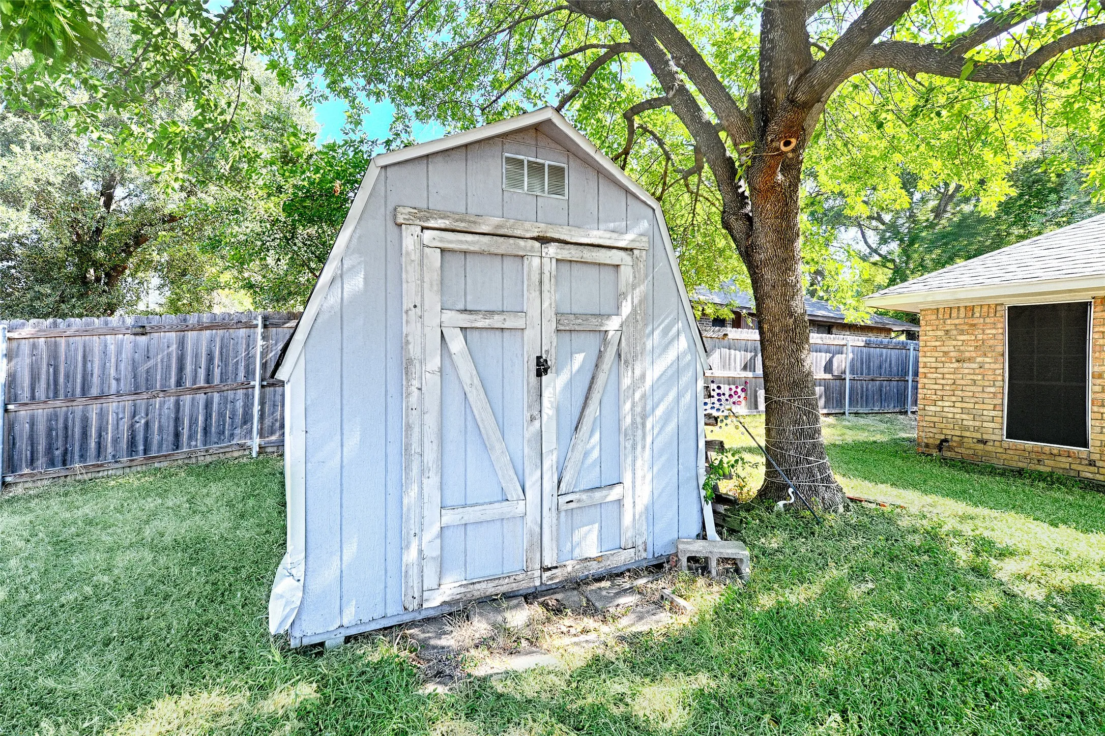 Storage shed with double barn doors and a small window