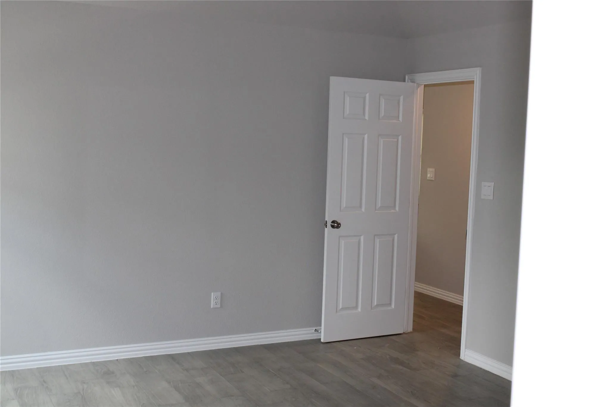 Wood-finish flooring, light gray wall paint, and white trim