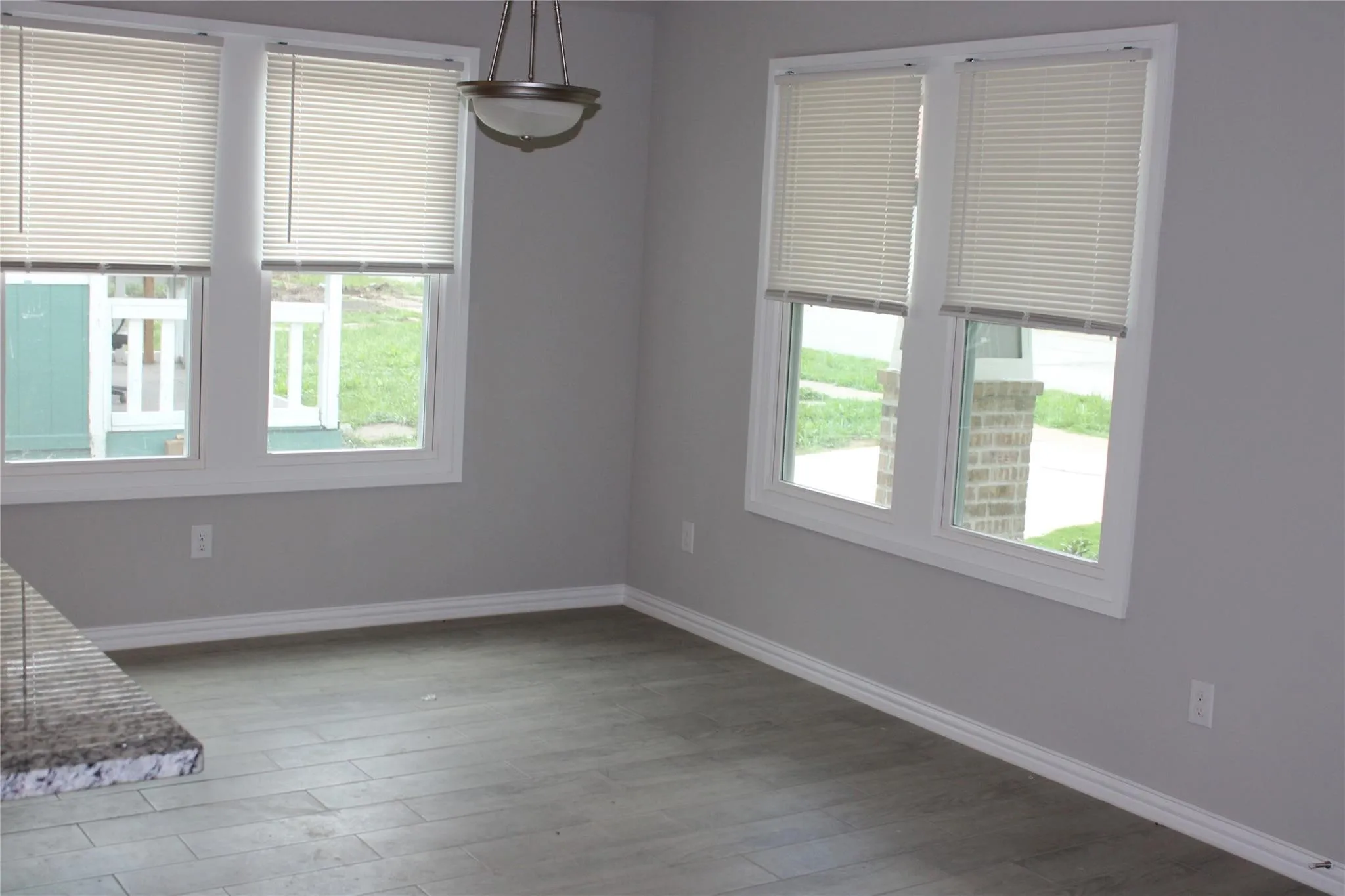 Wood-look flooring, light gray wall paint, and white window casings