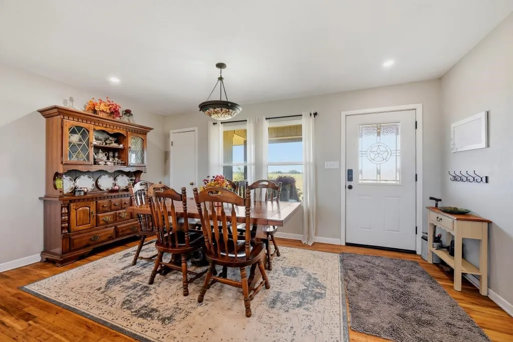 Wood-finish flooring, recessed lighting, and a decorative light fixture illuminate the space