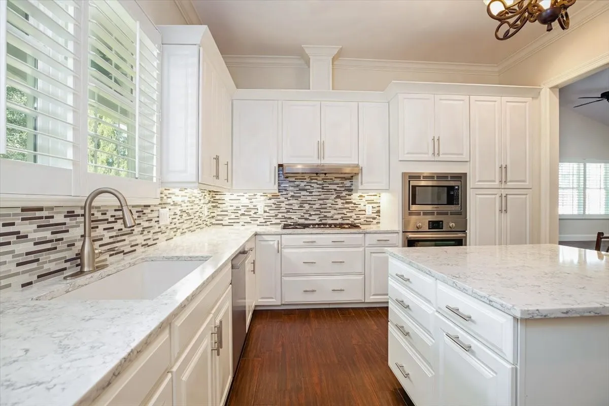 White cabinetry and a center island with light-toned countertops