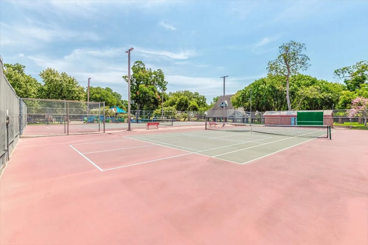 Tennis court facility featuring multiple courts, perimeter fencing, and overhead lighting