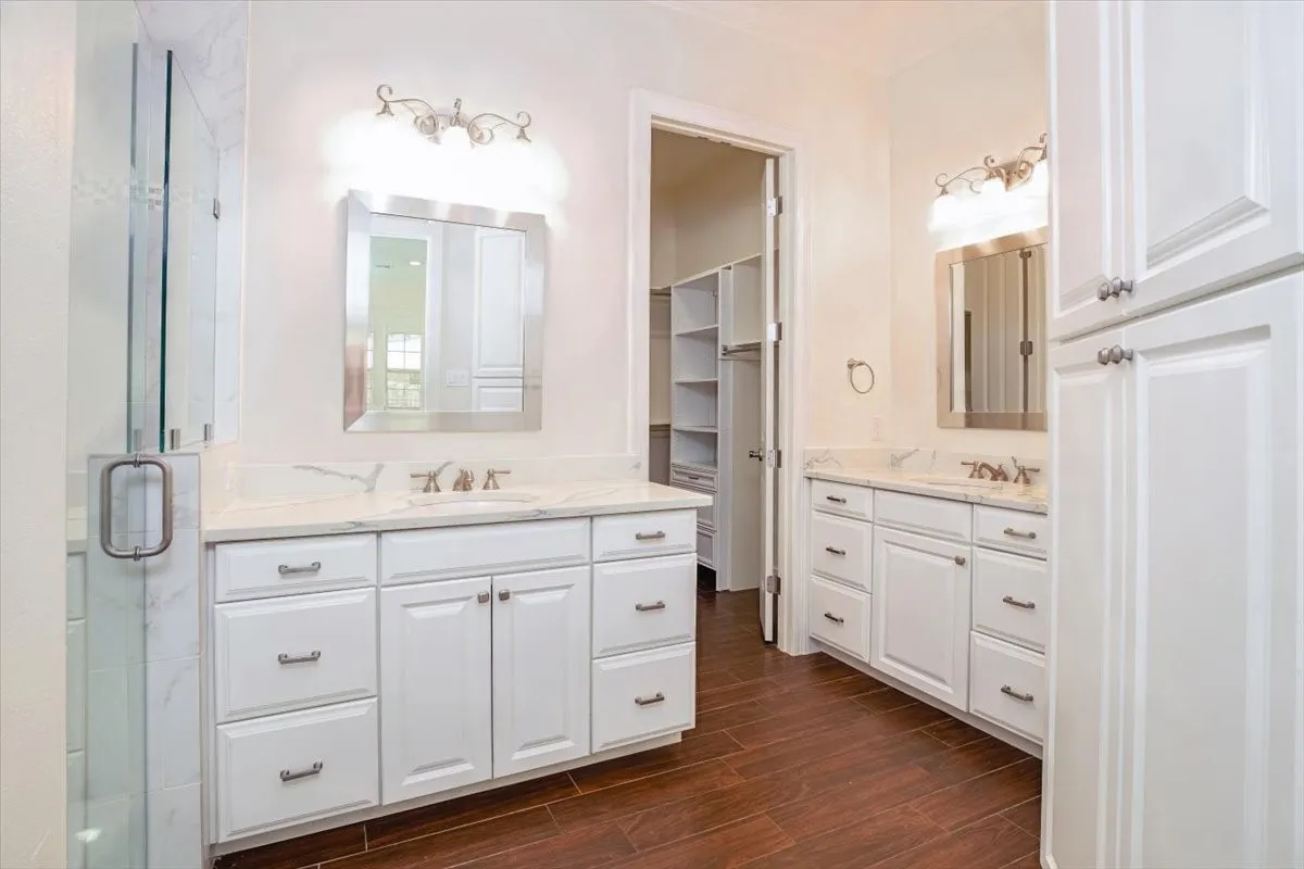 Dual vanities with white cabinetry, polished nickel hardware, and light-toned countertops