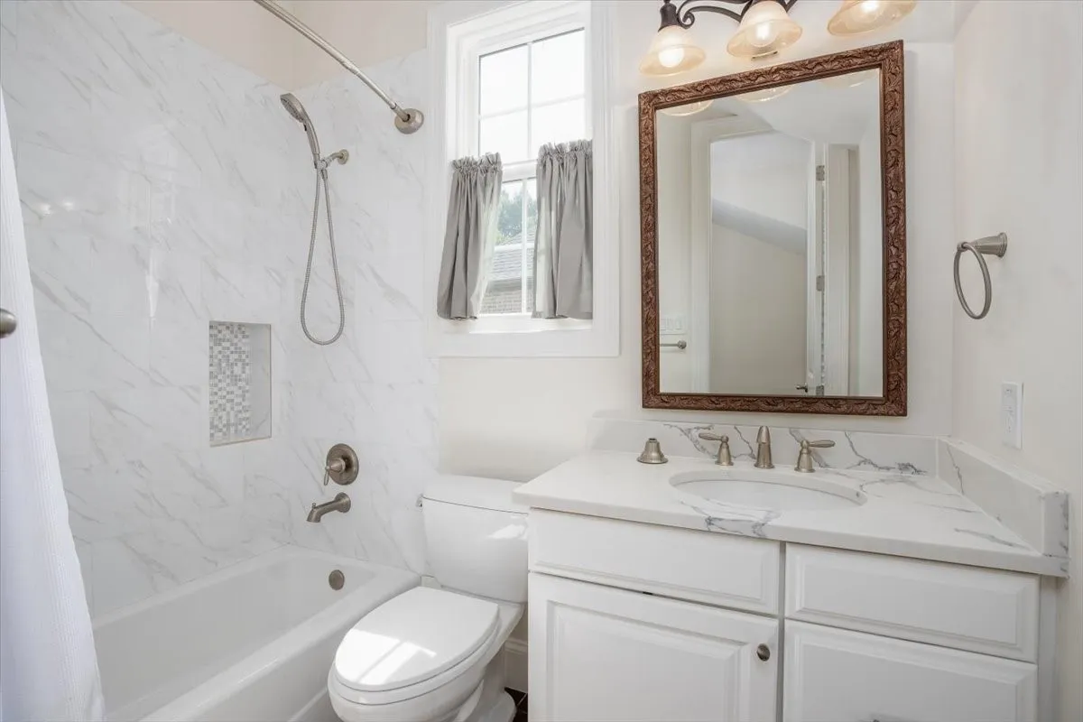 Jack and Jill Bathroom White vanity with a solid surface countertop, undermount sink, and brushed nickel fixtures