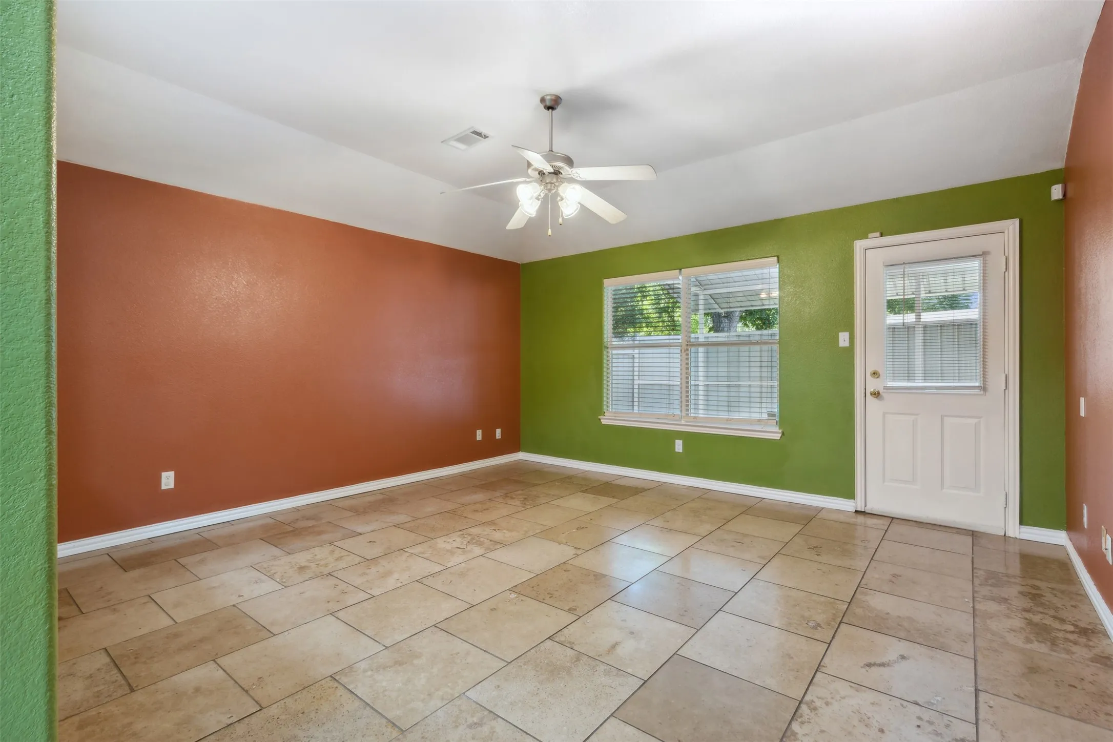 Tiled spare room featuring ceiling fan