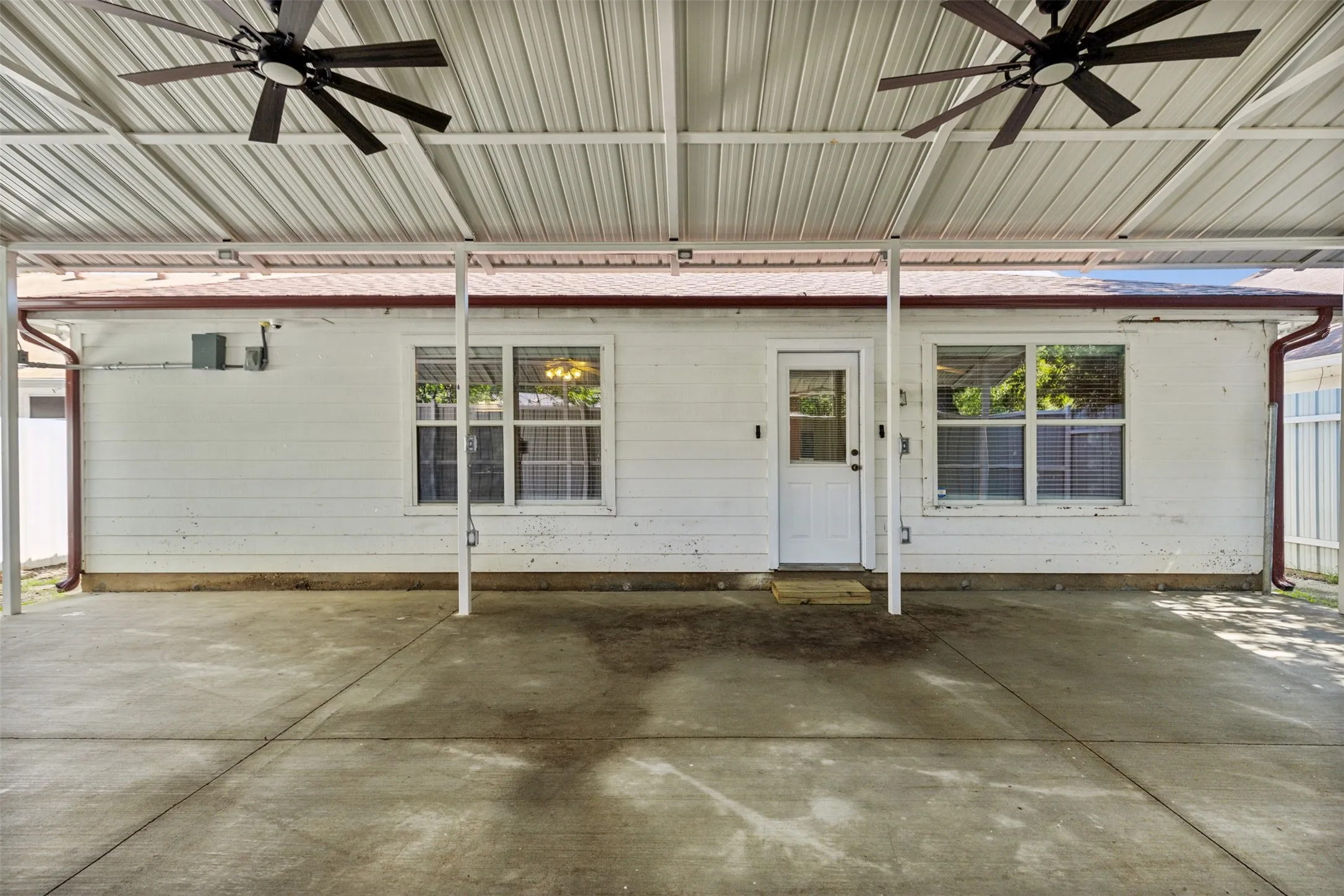 Doorway to property with ceiling fan and a patio area