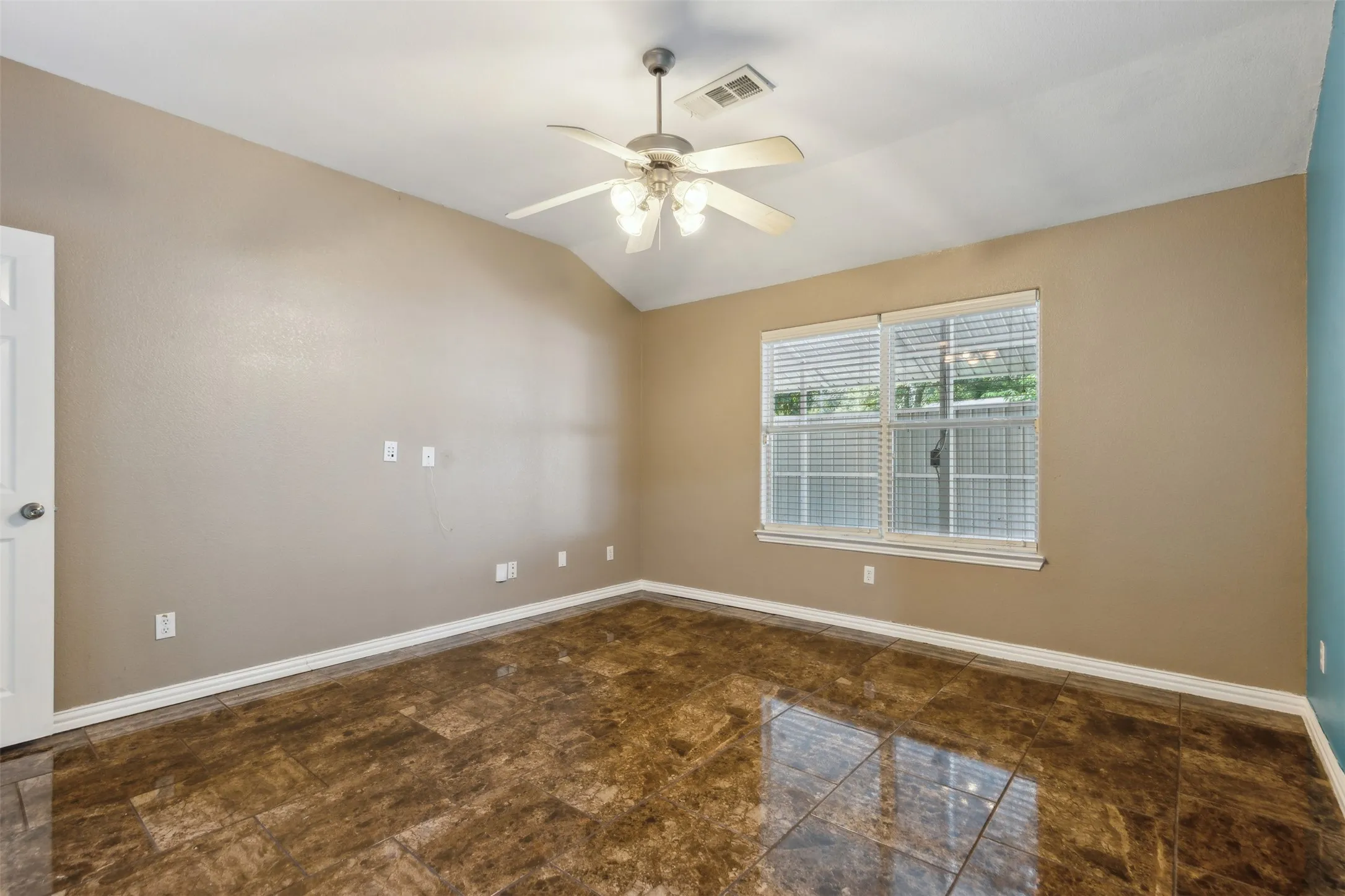Empty room with tile flooring, lofted ceiling, and ceiling fan