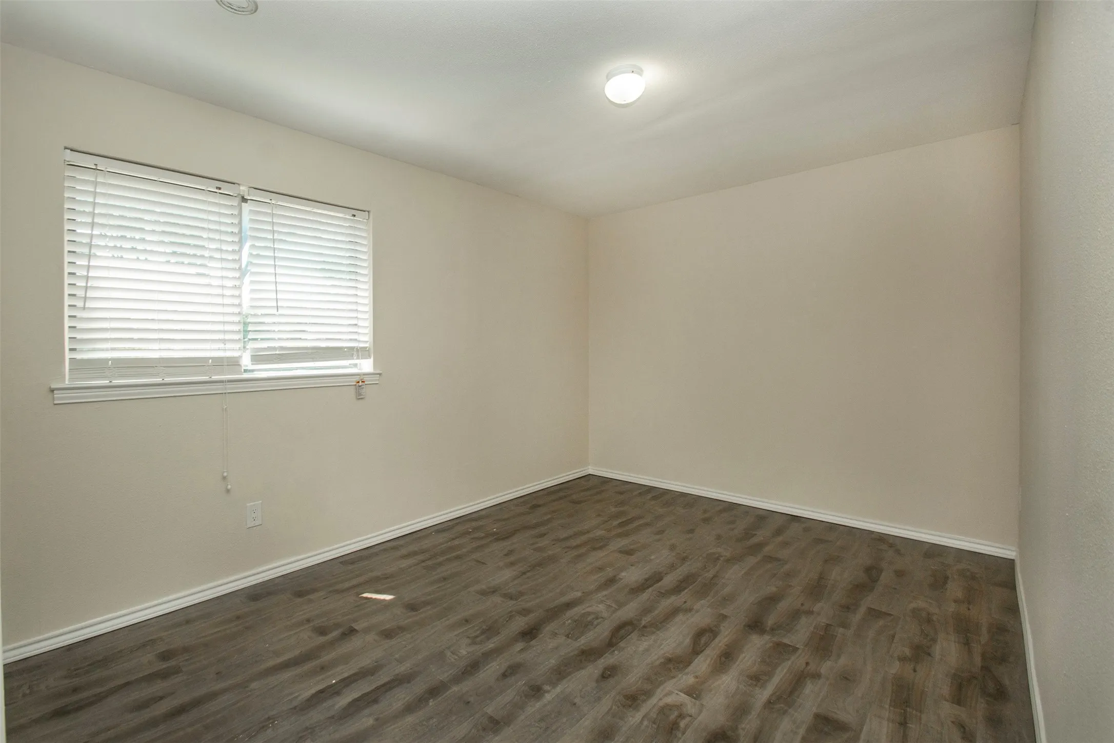 Hard-surface wood-finish flooring, recessed ceiling lighting, overhead flush-mount light fixture, and window with blinds