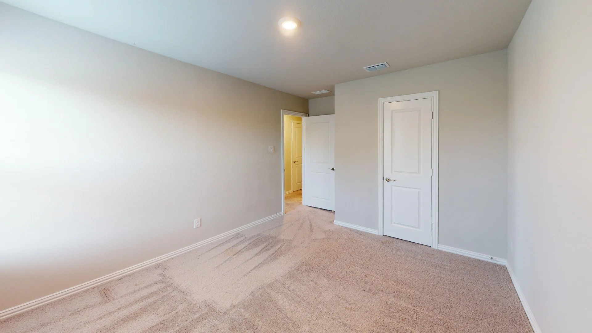 Neutral wall paint, light brown carpeting, white paneled doors, and recessed lighting