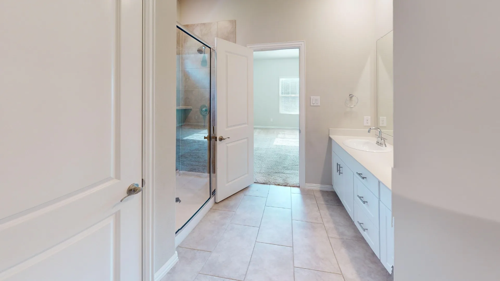 Full bathroom featuring a glass-enclosed shower with tiled walls, a single vanity with a solid surface countertop, an undermount sink, and tile flooring