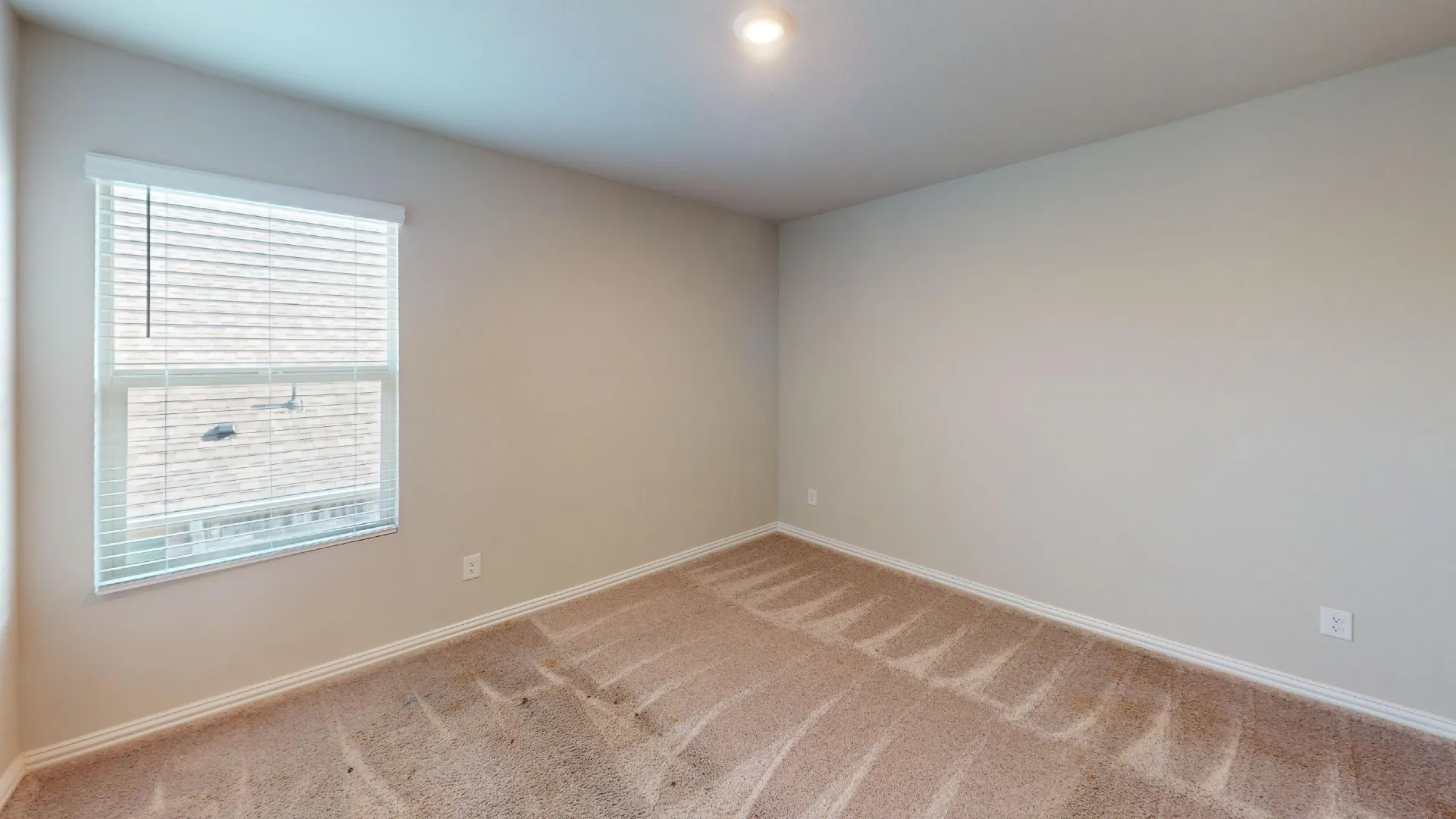 Recessed lighting with light neutral wall paint and carpet flooring