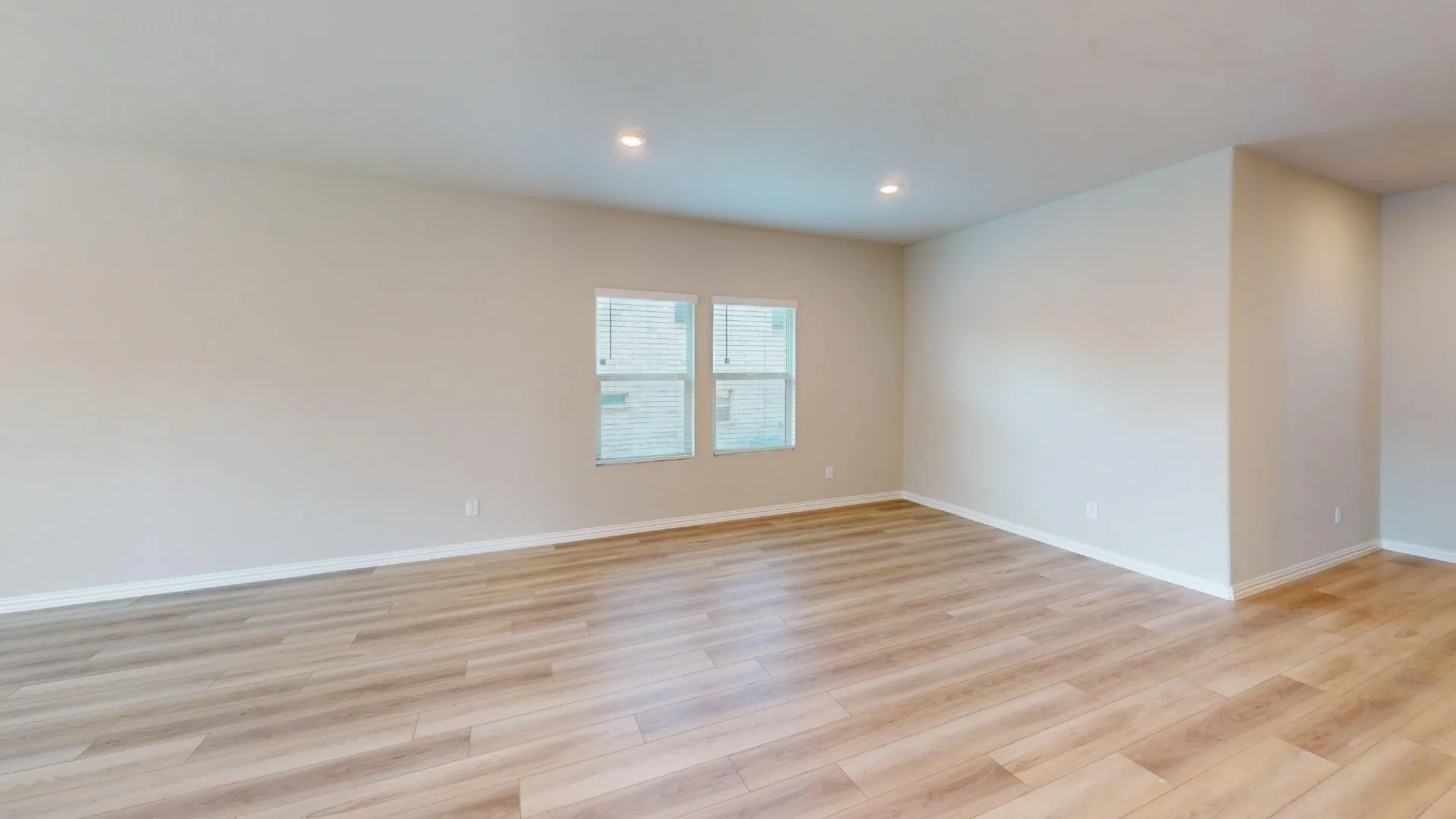 Expansive room featuring wood-finish flooring, recessed lighting, and multiple windows