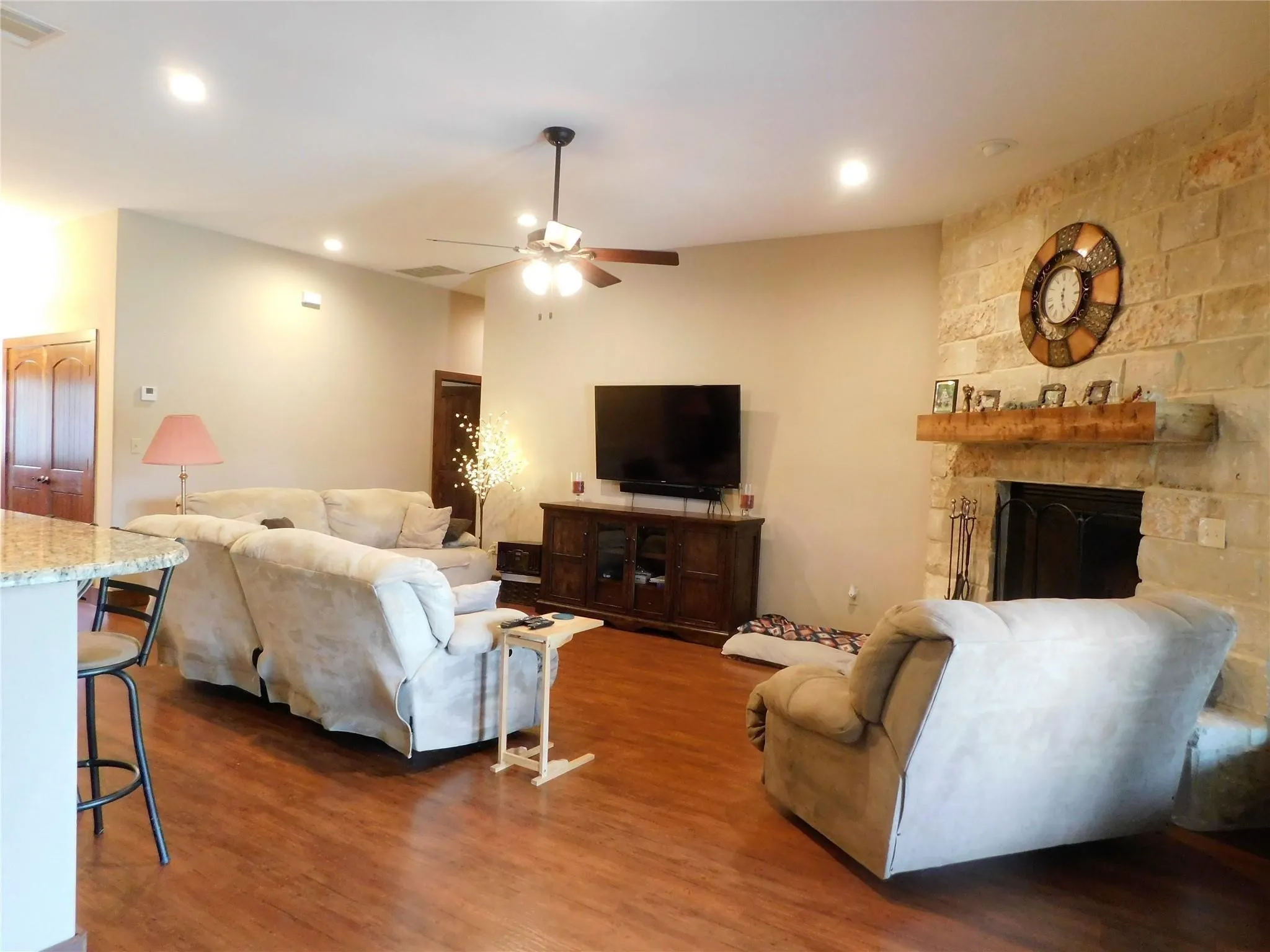 Large living area with stone fireplace with blower. All 3 sofas that recline stays with the TV