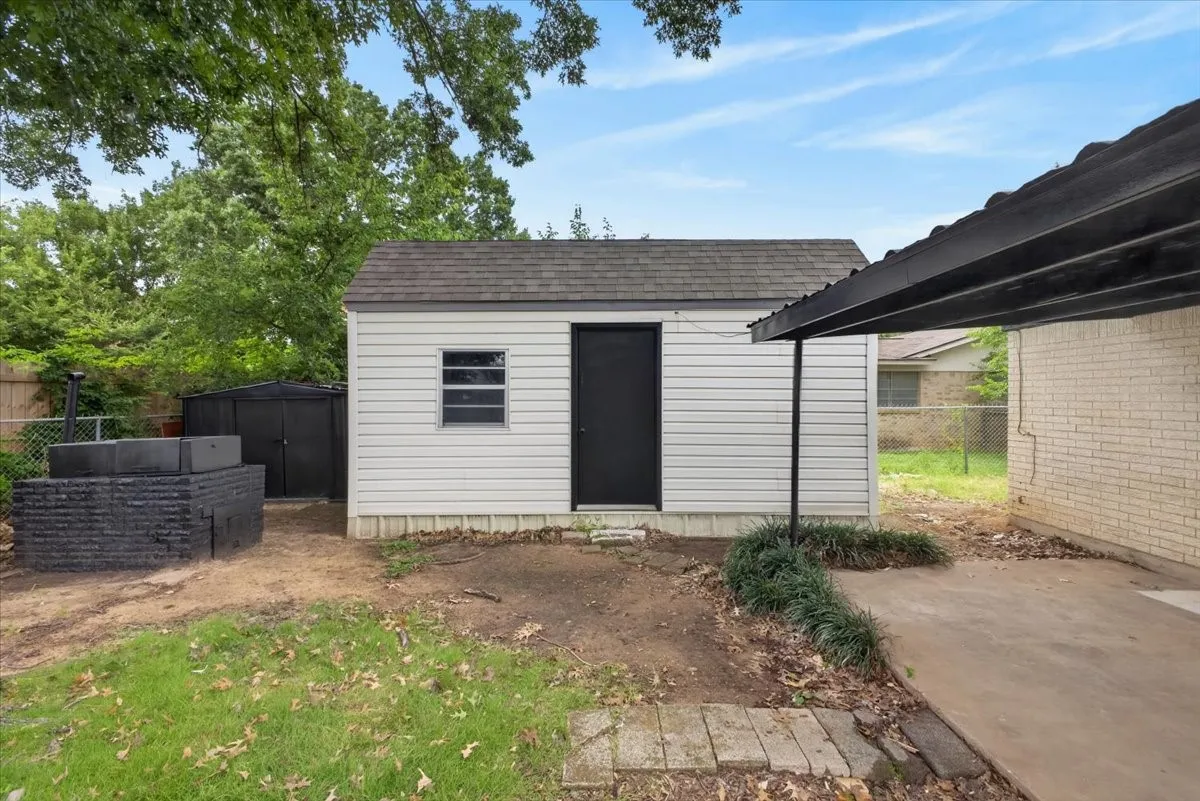 Detached storage shed with a single window and dark door