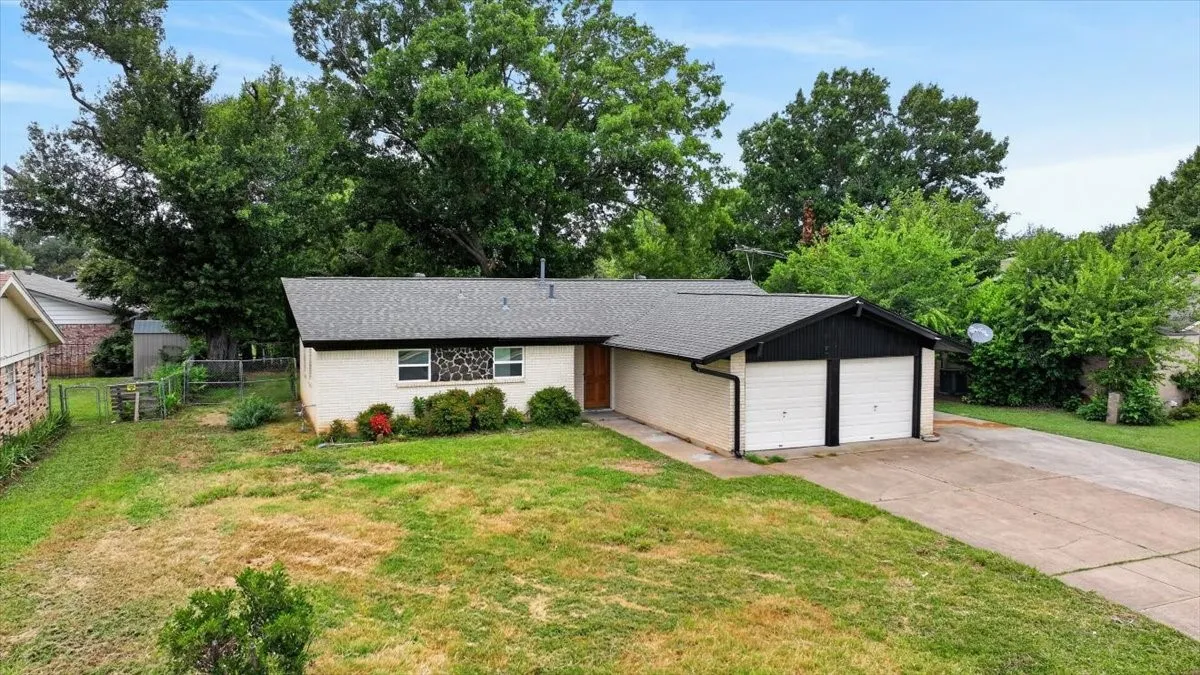 White brick exterior with a dark shingle roof