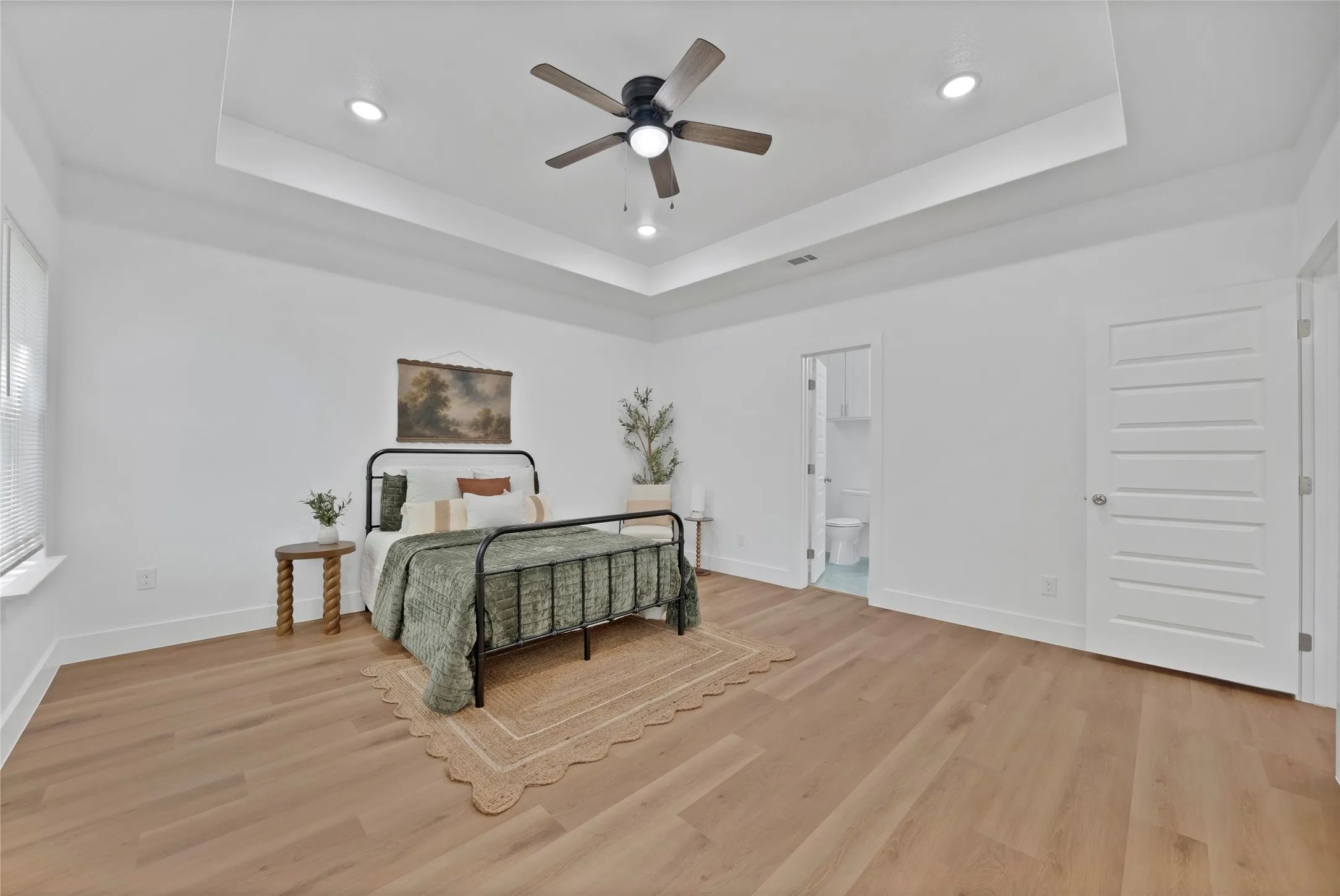 Recessed lighting, wood-finish flooring, and tray ceiling with a built-in ceiling fan