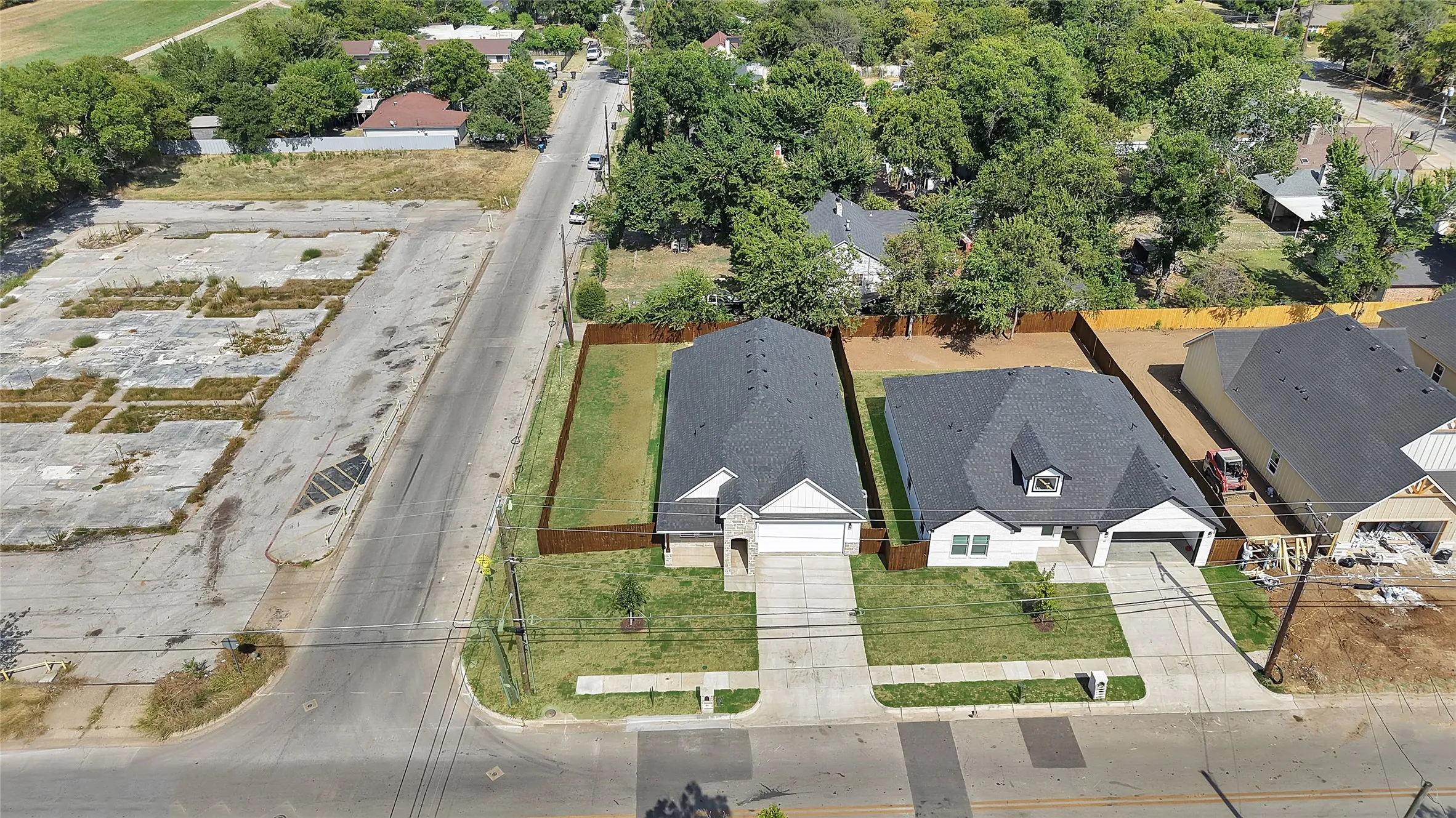 New construction residence featuring a dark shingle roof, light-colored siding, an attached garage, and a concrete driveway