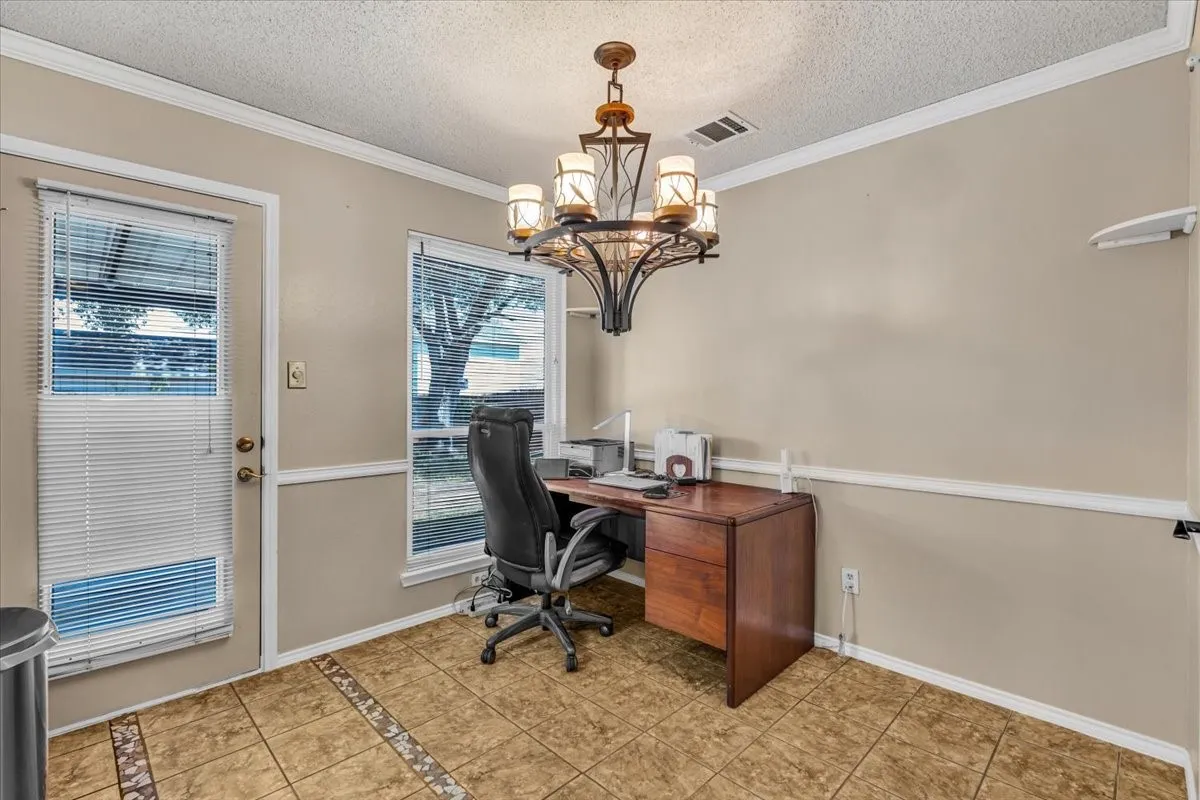 Tiled flooring with decorative inlay, chandelier lighting, and a single-light door
