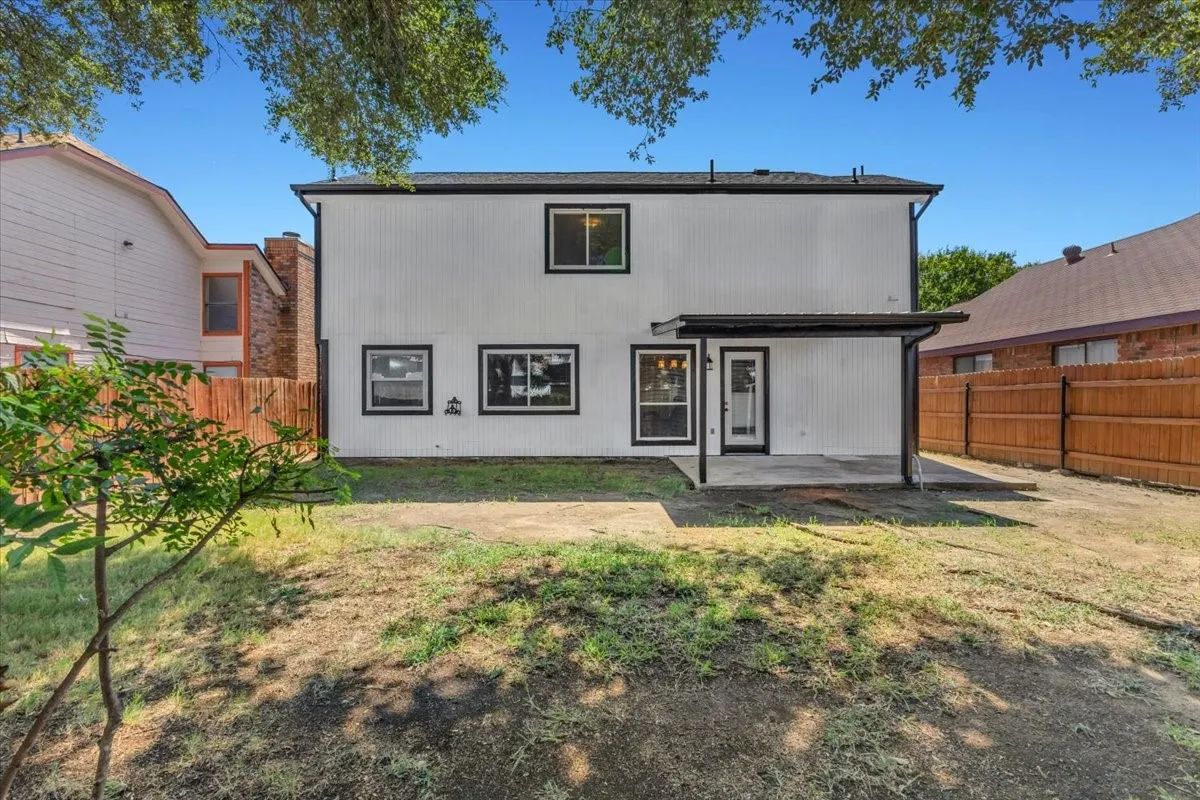 Two-story exterior with white siding and black trim accents