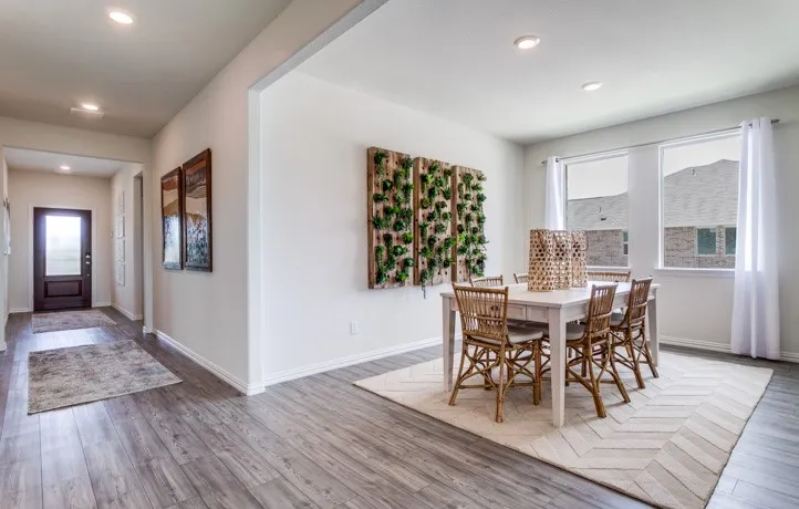 Wood-finish flooring extends throughout the entry and into the dining area