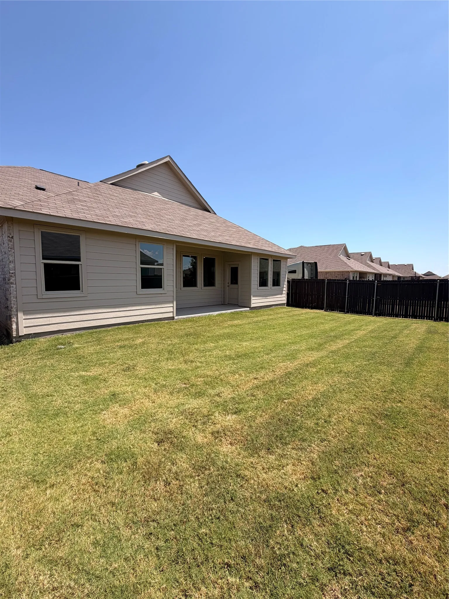 Spacious single-story residence with a covered front porch, featuring composite or vinyl siding exterior, pitched roofline with architectural shingles, and multiple front-facing windows