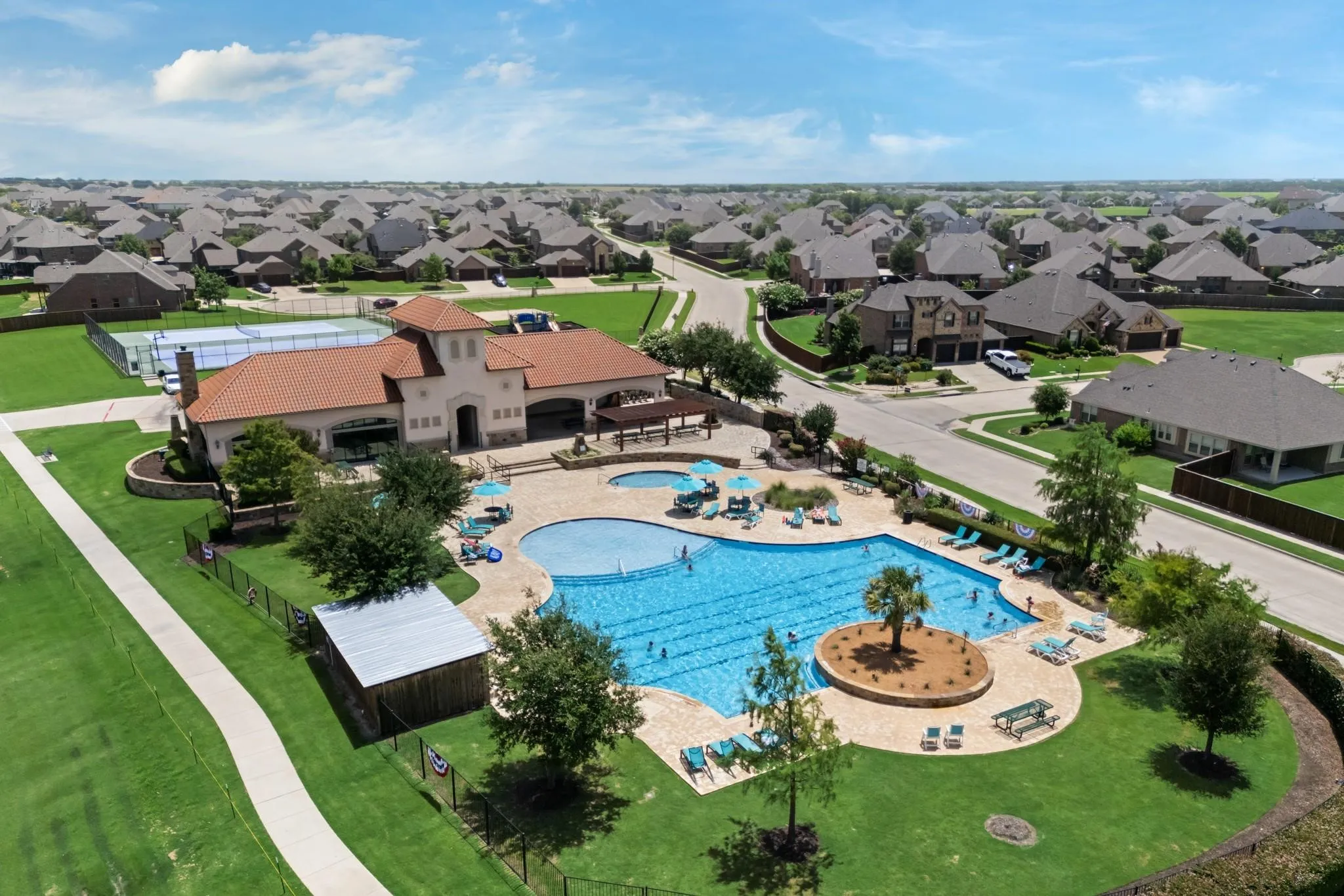 Community amenity center featuring a resort-style swimming pool, separate children's pool, and tennis courts