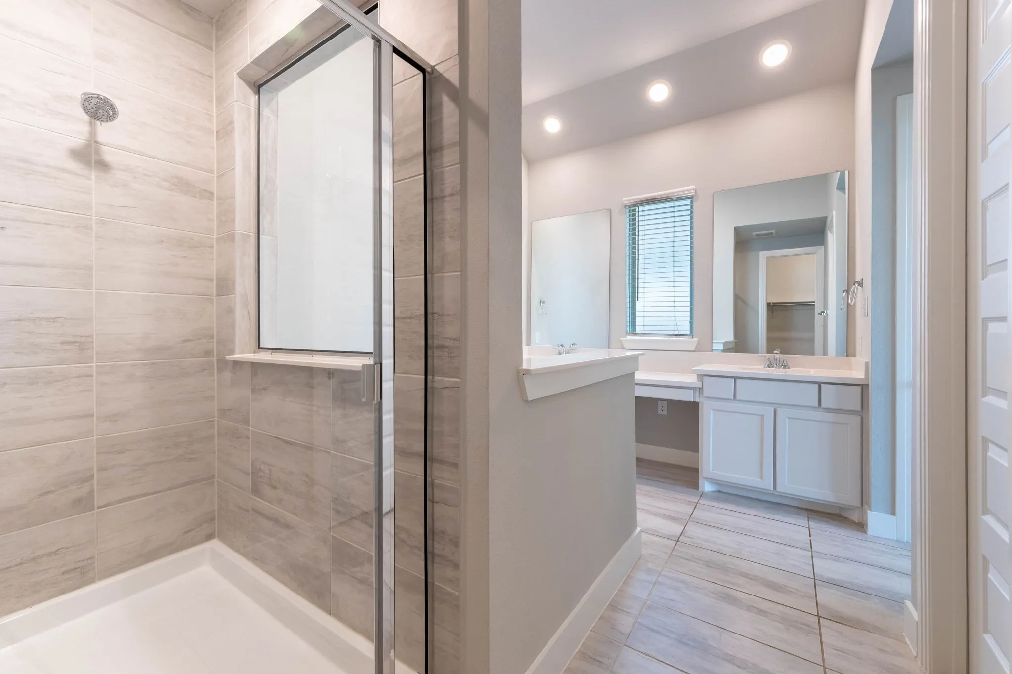 Glass-enclosed shower with tiled walls and a built-in shelf