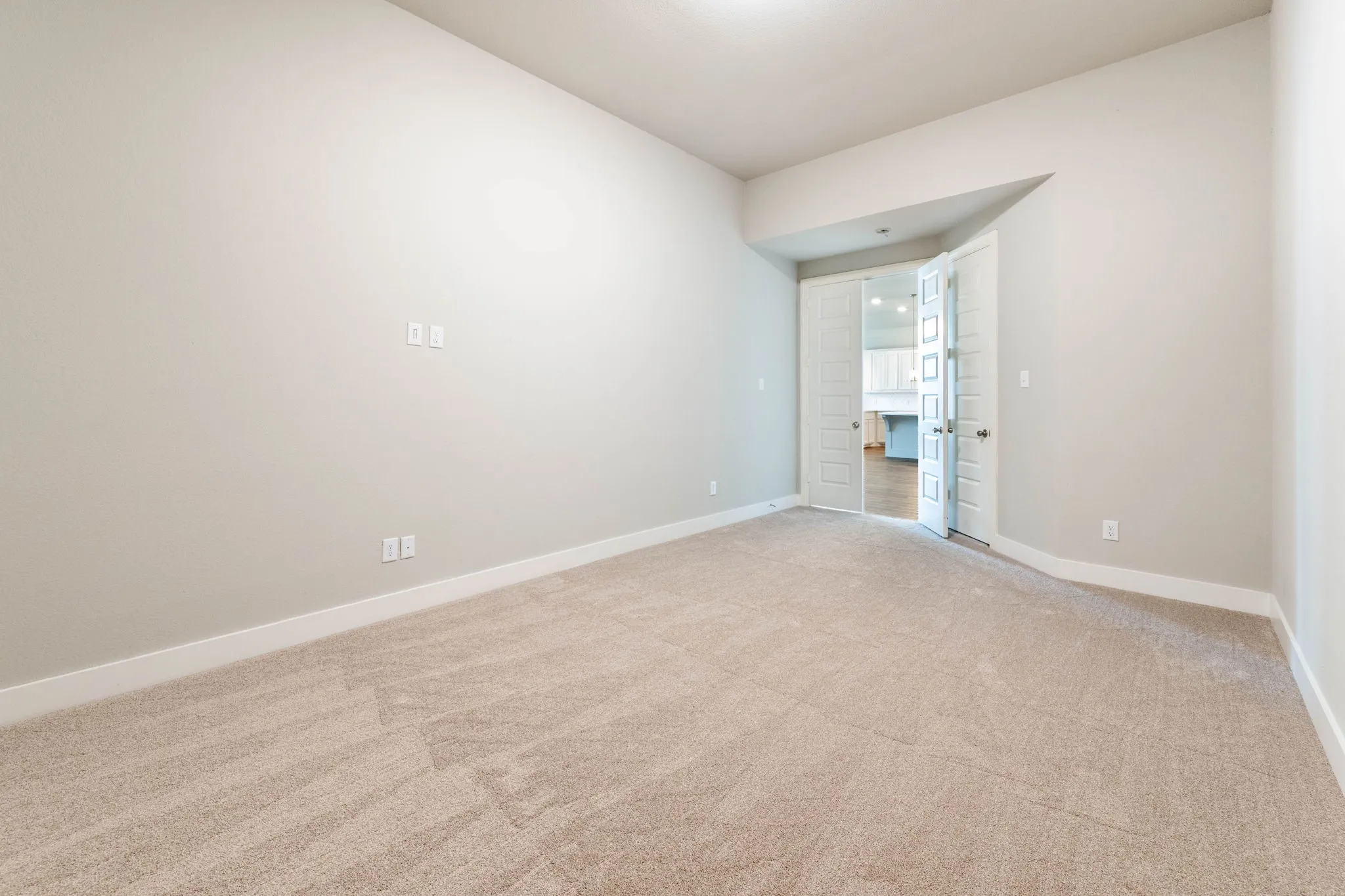 Recessed lighting, light-toned carpeting, neutral wall finishes, and double French doors with transom