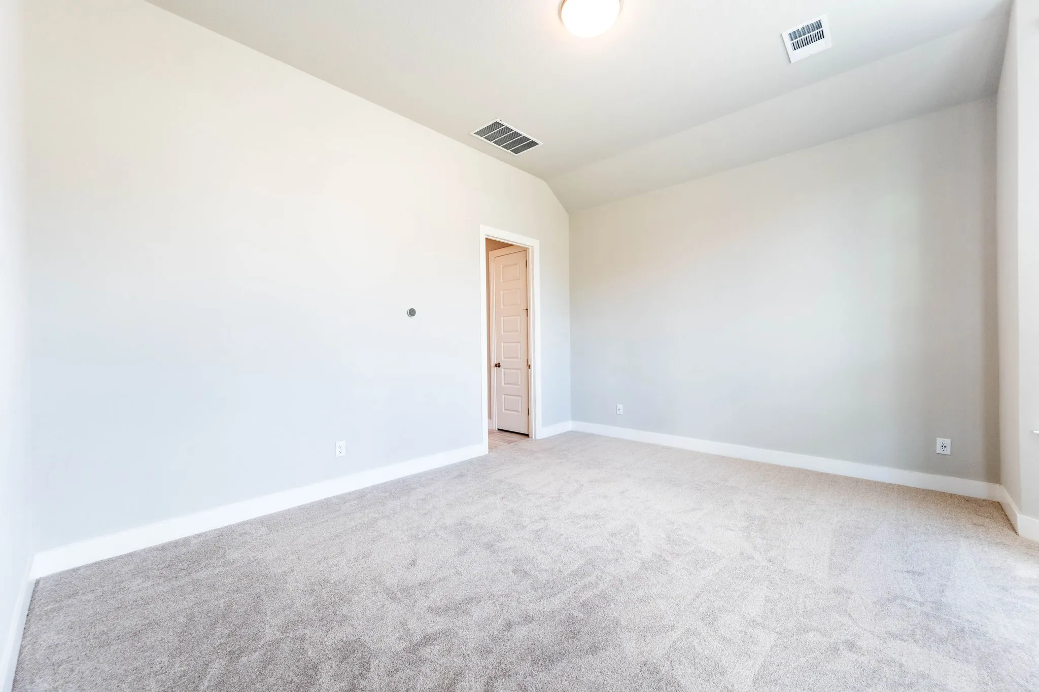 Carpeted flooring with light-toned walls and ceiling, featuring a flush-mount light fixture
