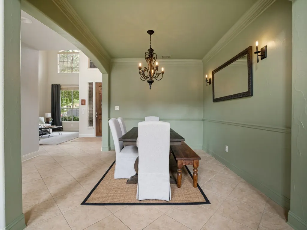 Formal dining room with architectural archways, crown molding and decorative lighting, offering a defined yet connected space for entertaining.