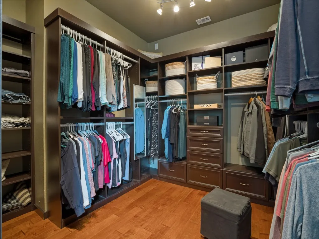 Custom California Closets walk-in closet featuring extensive built-in storage, cabinetry and organization in the first-floor primary suite.