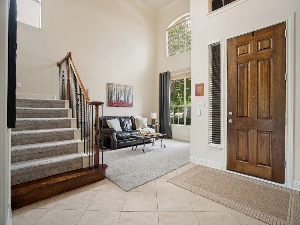 Light-filled two-story foyer with tall windows and a flexible front living area, creating a welcoming first impression.