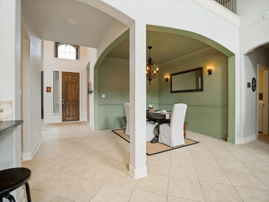 Elegant formal dining room with architectural arches, crown molding and direct connection to the main living areas—ideal for entertaining in this Flower Mound home.