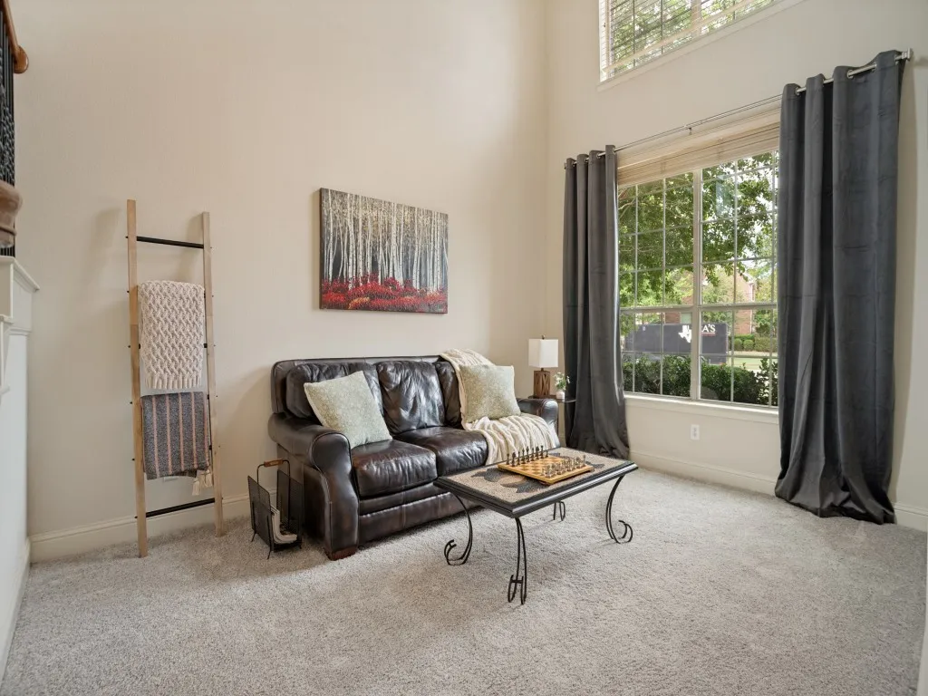 Versatile front living space with soaring ceiling and abundant natural light—ideal for a sitting room, music room or additional gathering space.