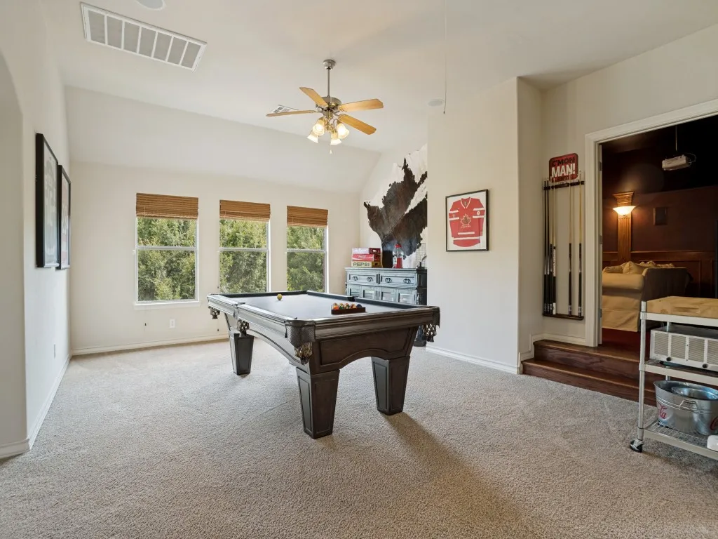 Large upstairs game room with vaulted ceiling, abundant natural light and direct access to the dedicated home theatre.
