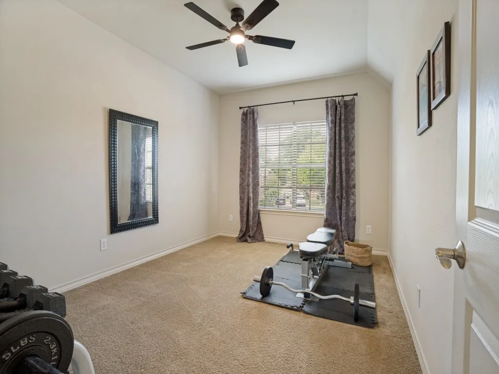 Additional upstairs bedroom with walk-in closet and abundant natural light, offering flexibility for a bedroom, fitness space or hobby room.